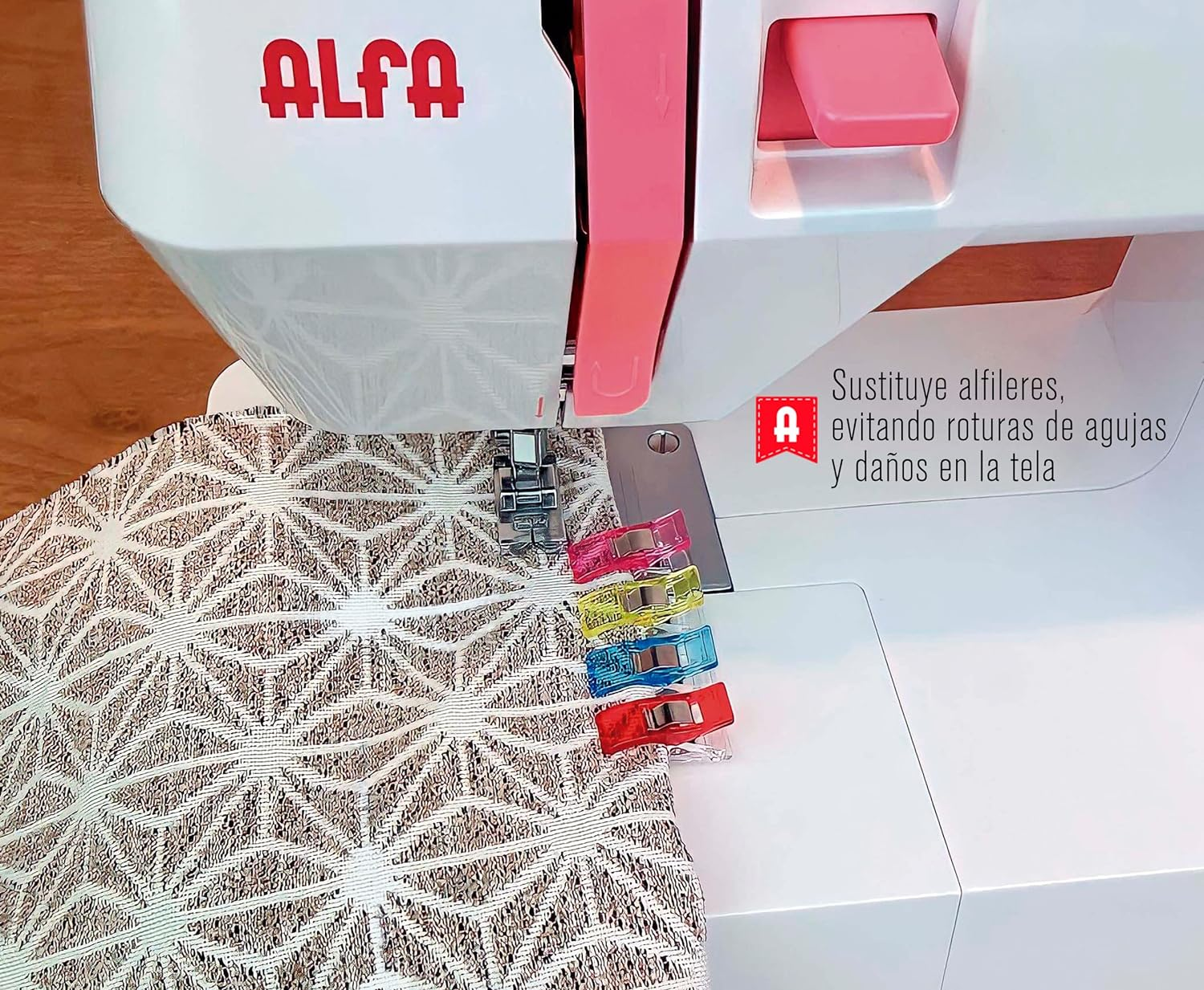 Una máquina de coser con tela y clips coloridos, con texto: 'Sustituye alfileres, evitando roturas de agujas y daños en la tela'.