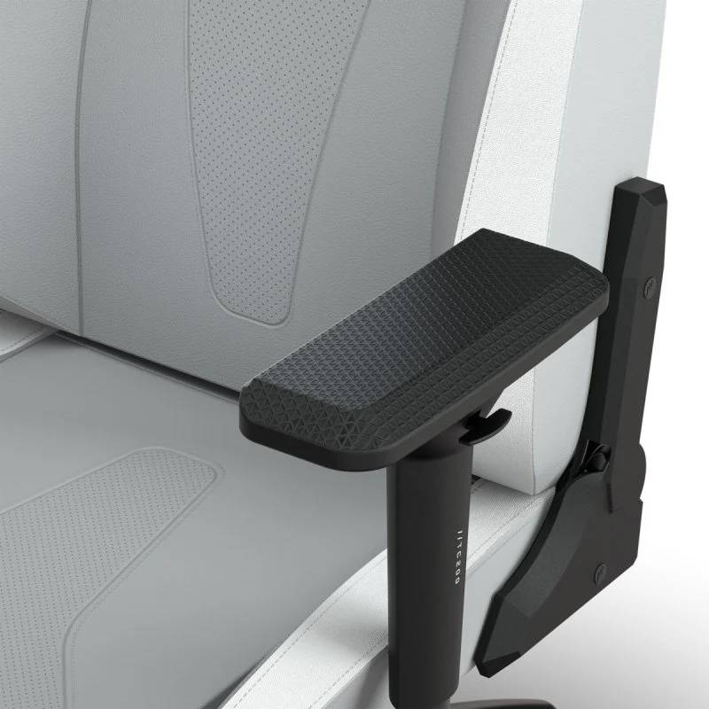 Primer plano del reposabrazos negro y gris de una silla gamer, texturizado y ergonómico.