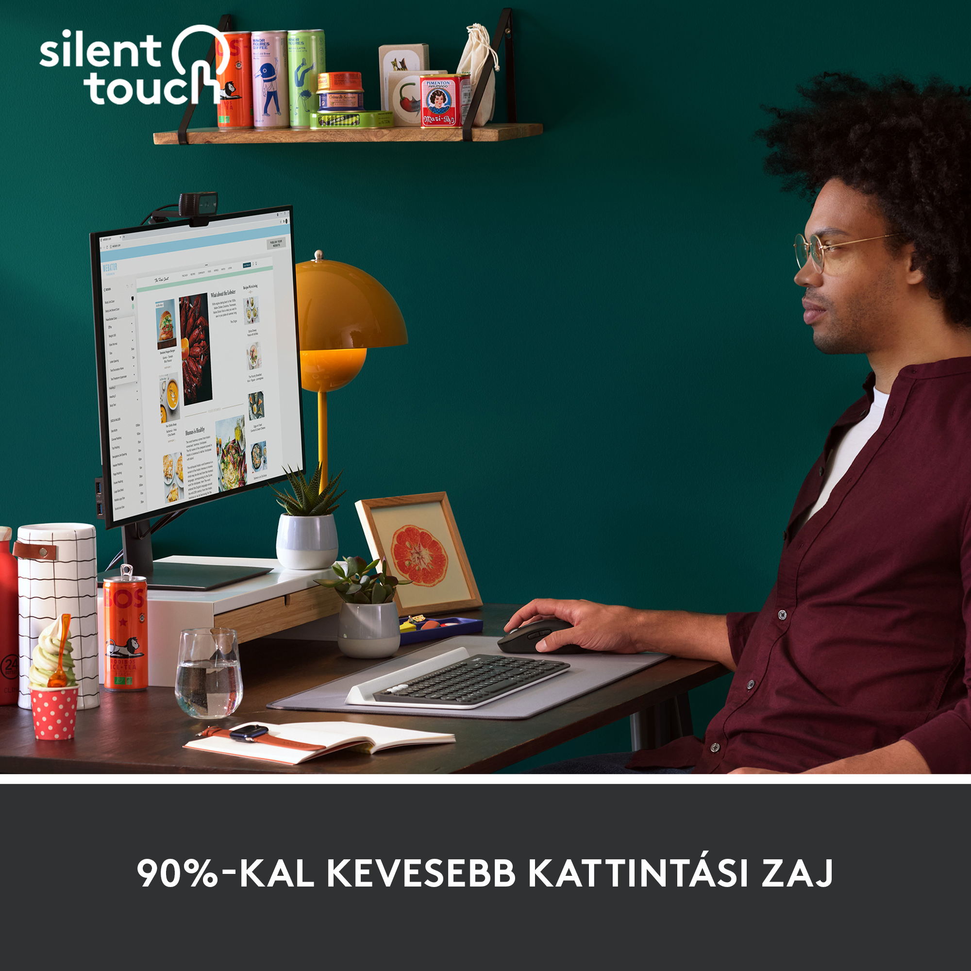 Férfi az asztalnál billentyűzetet és Logitech egeret használ. Zöld fal a háttérben.