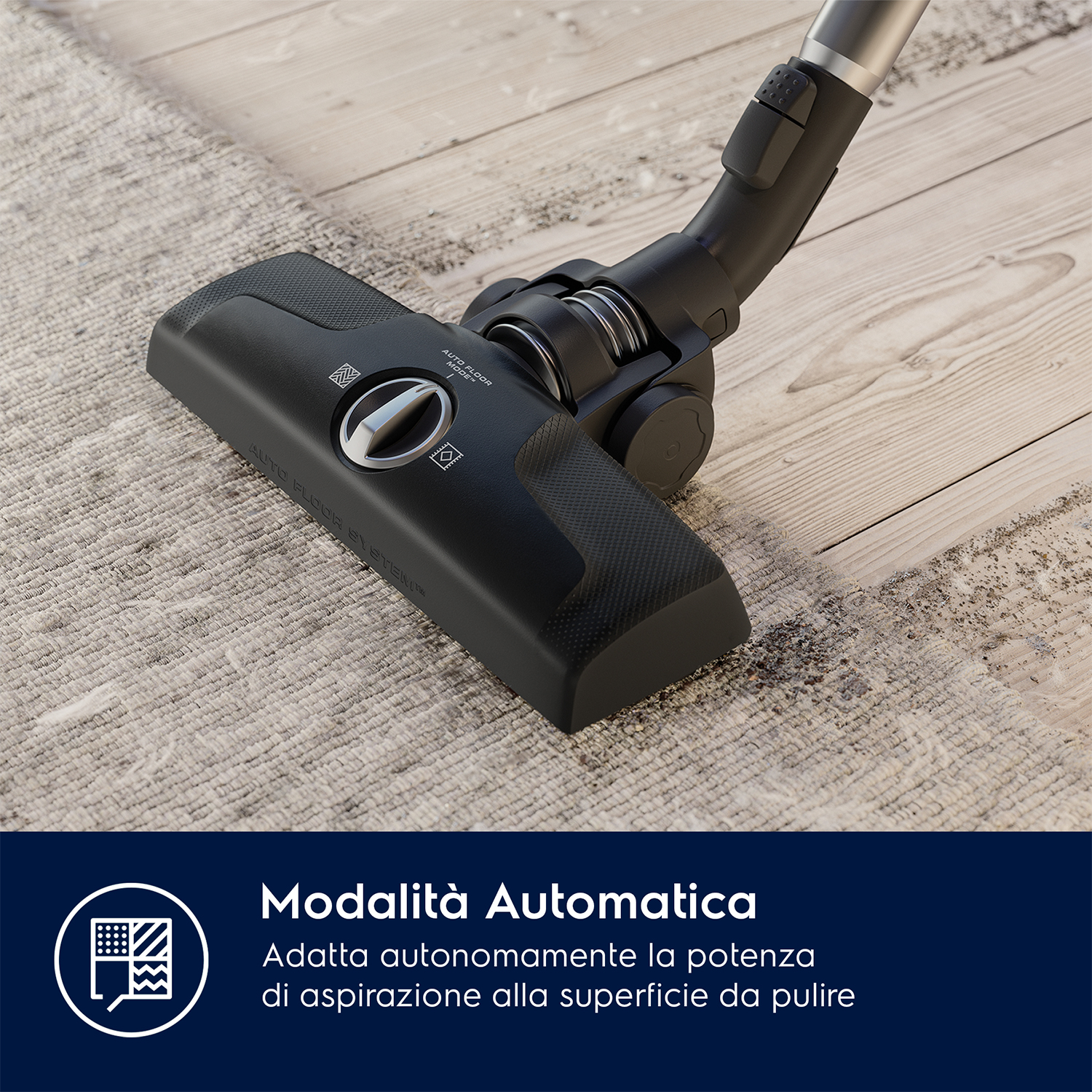 Testa aspirapolvere nera che pulisce un tappeto chiaro su un pavimento in legno. L'impugnatura è in alto.