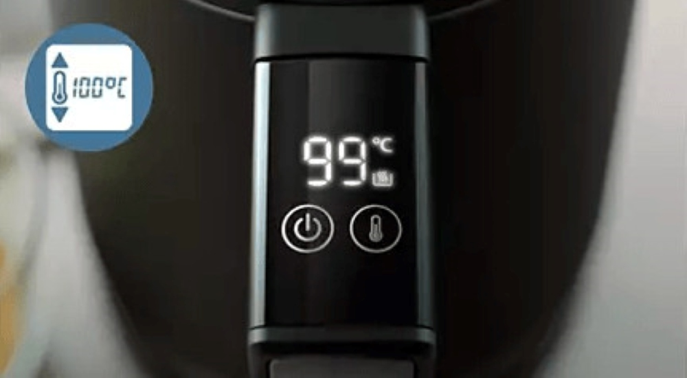 Zbliżenie na czarny wyświetlacz frytkownicy powietrznej, pokazujący 99°C, ikona regulacji temperatury.