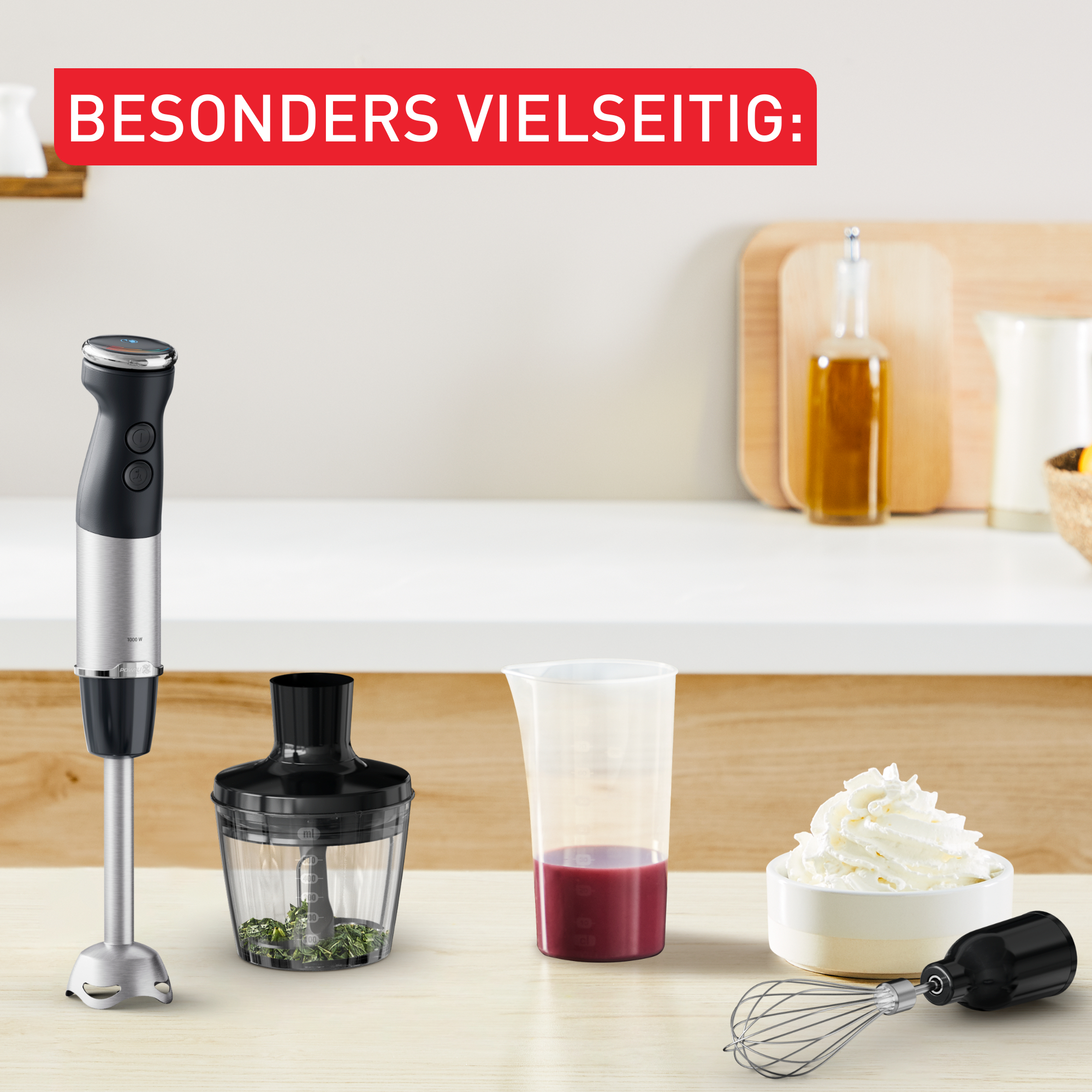 Stabmixer mit Zubehör auf einer Theke, Text: BESONDERS VIELSEITIG (SEHR VIELSEITIG).