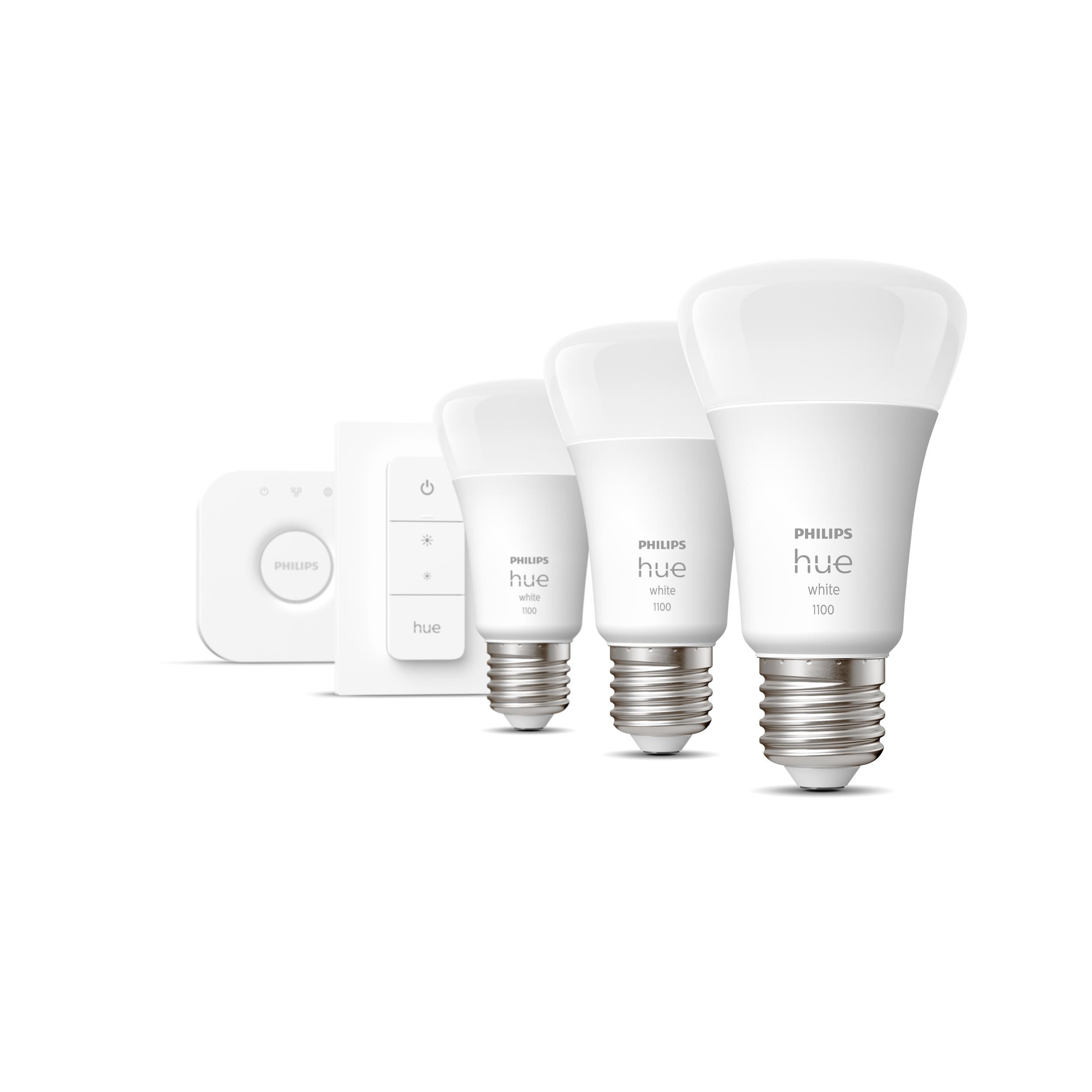 Vier weiße Philips Hue Smart-Glühbirnen und eine Hue Bridge auf weißem Hintergrund.