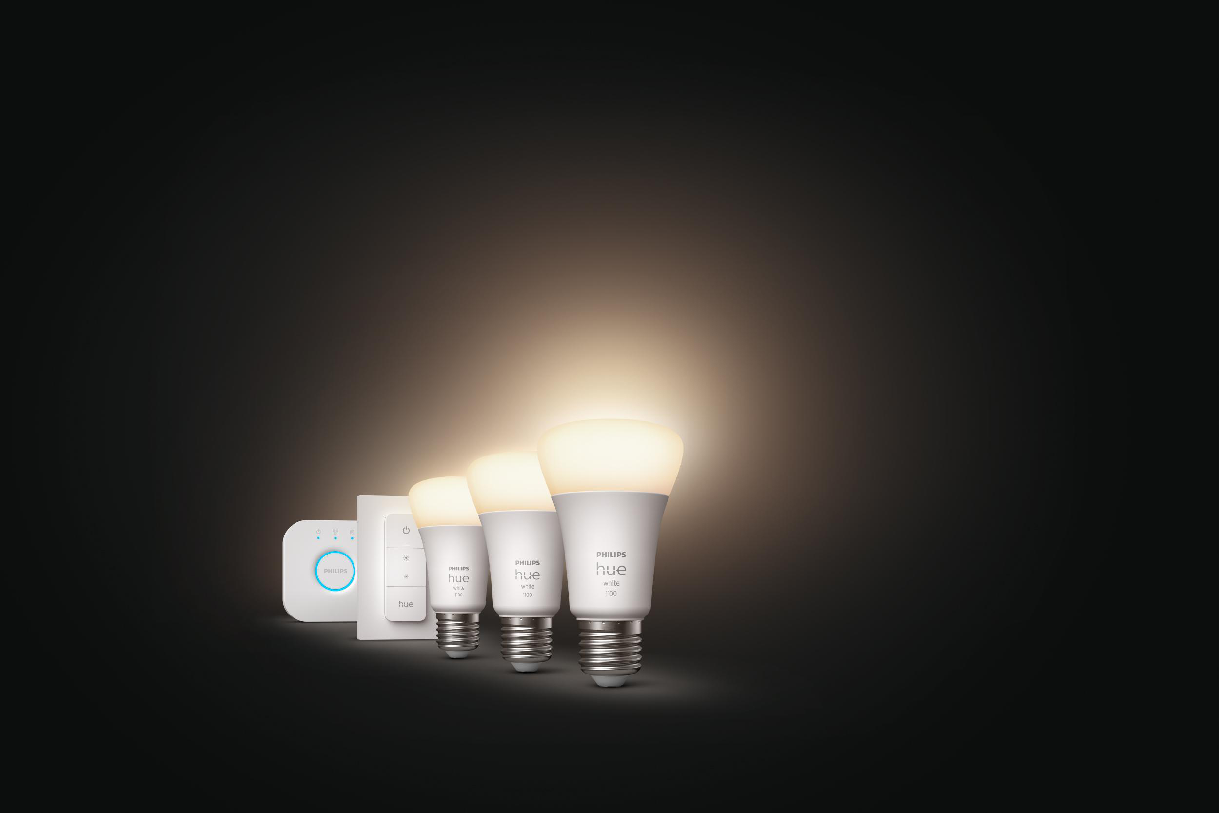 Eine Gruppe von Philips Hue Smart-Glühbirnen und zugehörigem Zubehör auf dunklem Hintergrund.