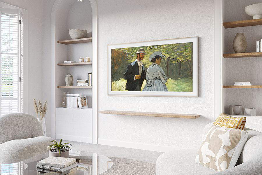 Ein Samsung-Fernseher an einer weißen Wand. Es gibt Regale, eine Couch und ein Gemälde von Menschen in einem Park.