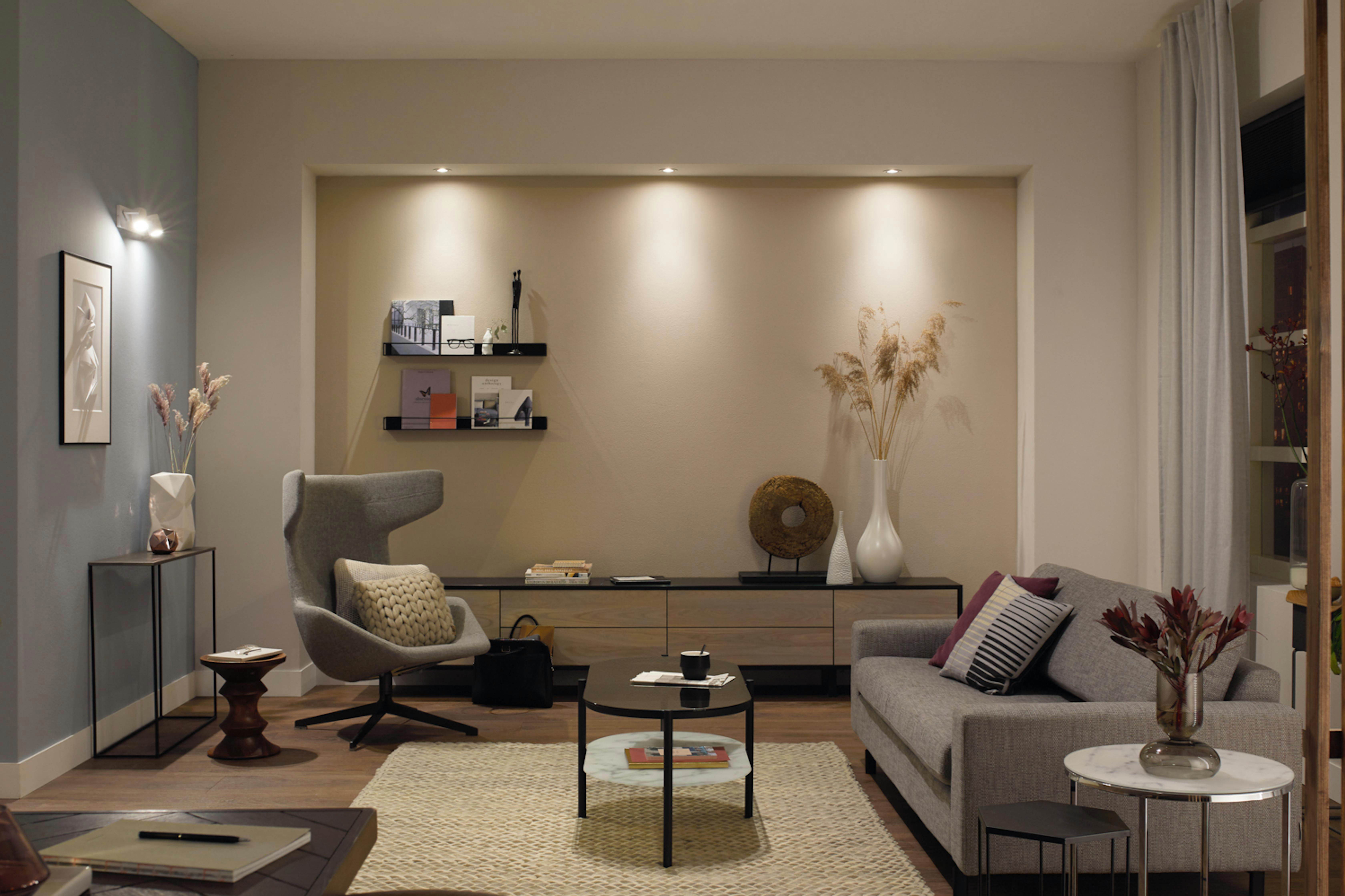 Wohnzimmer mit Möbeln, Sofa, Sessel, Couchtisch und dekorativen Elementen.