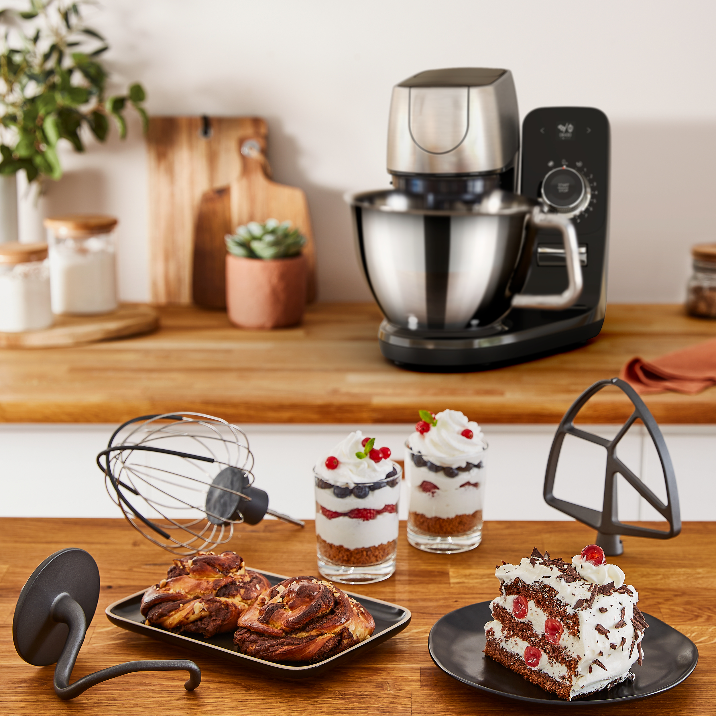 Küche mit Essen, Standmixer und Zubehör auf einer Holz-Arbeitsplatte.