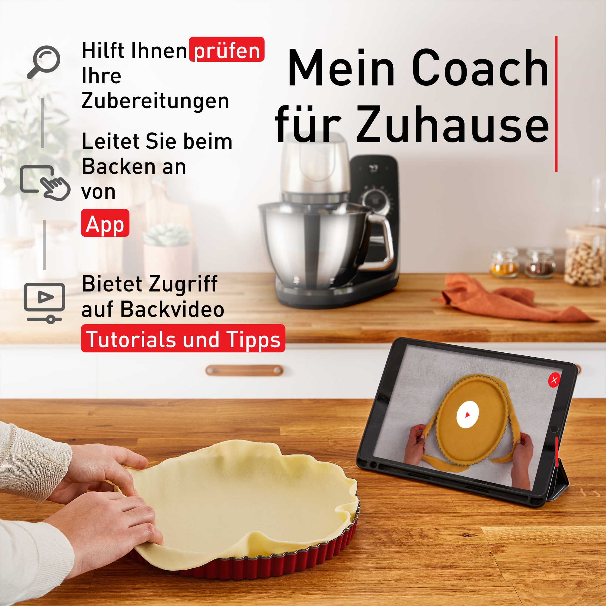 Hände bereiten Teig in roter Tartform vor, Koch-App auf Tablet, Küche im Hintergrund.