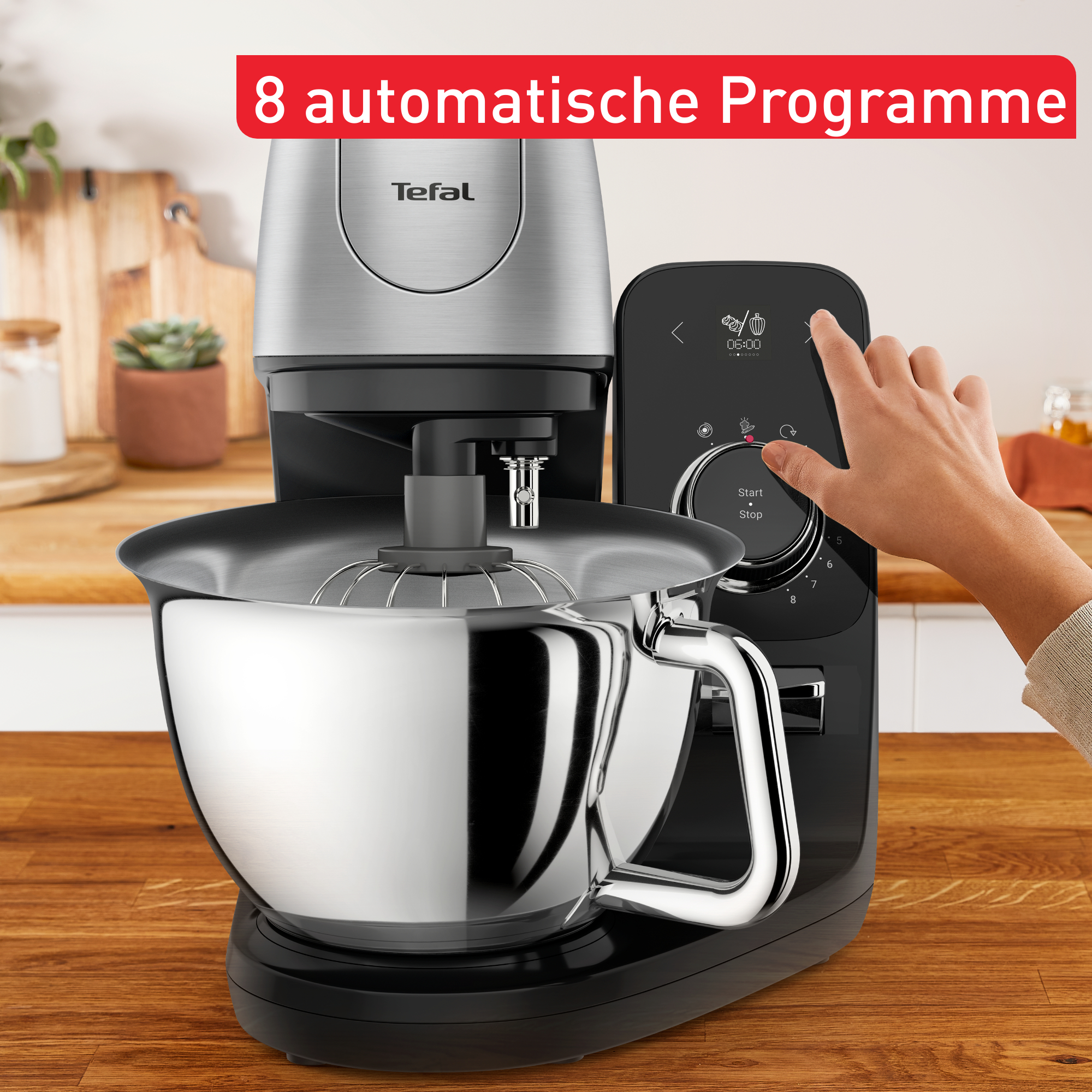 Eine Hand berührt den Touchscreen einer Küchenmaschine mit Text und Metallschüssel.