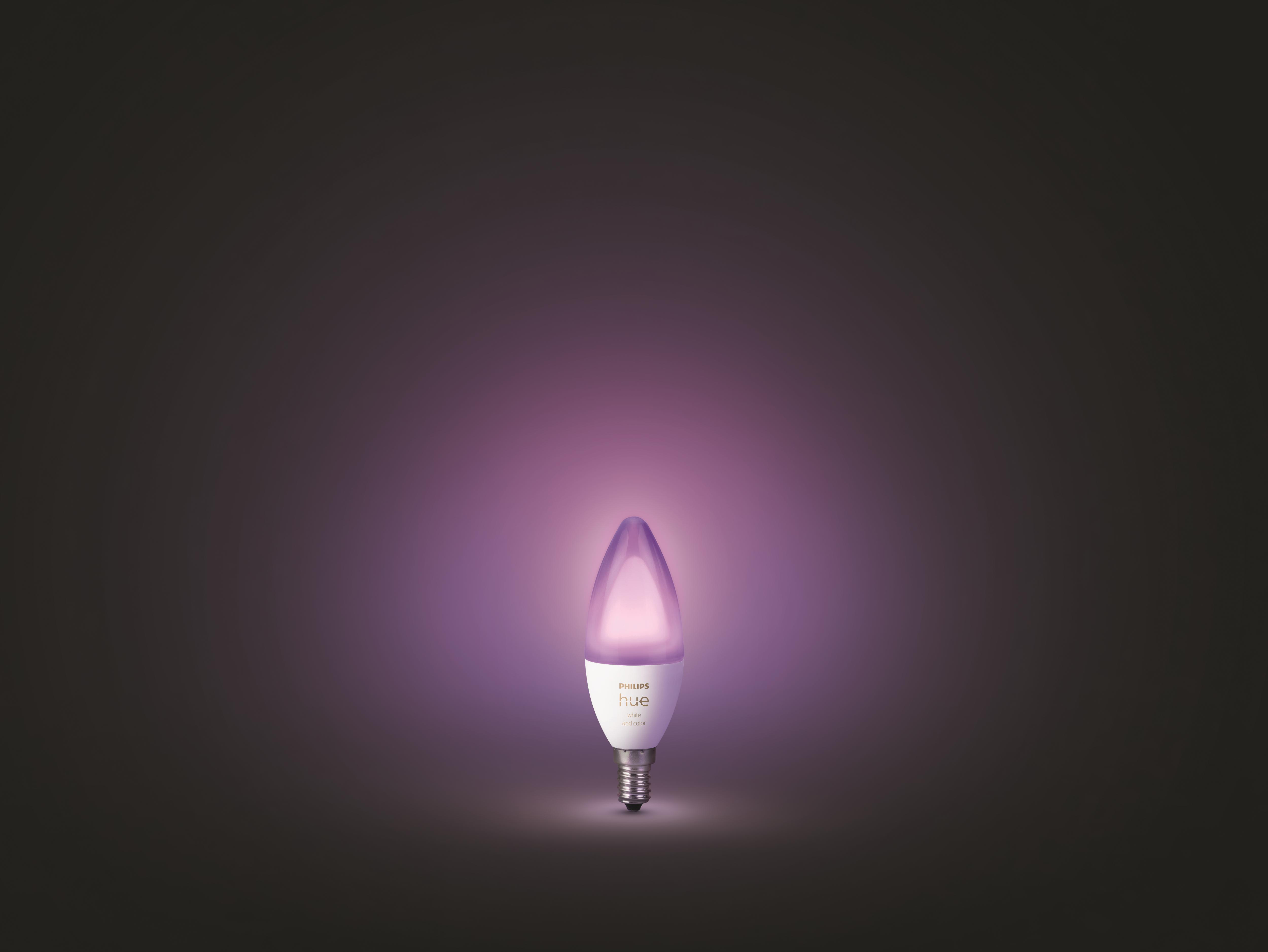 Eine Philips Hue Glühbirne, die ein lilafarbenes Leuchten vor dunklem Hintergrund ausstrahlt.