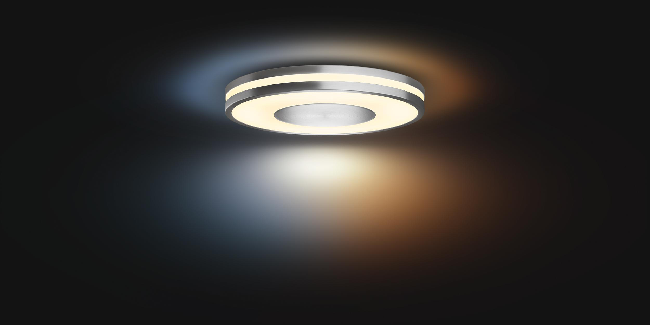 Eine kreisförmige, silberne Leuchte auf dunklem Hintergrund. Sie strahlt Licht aus.