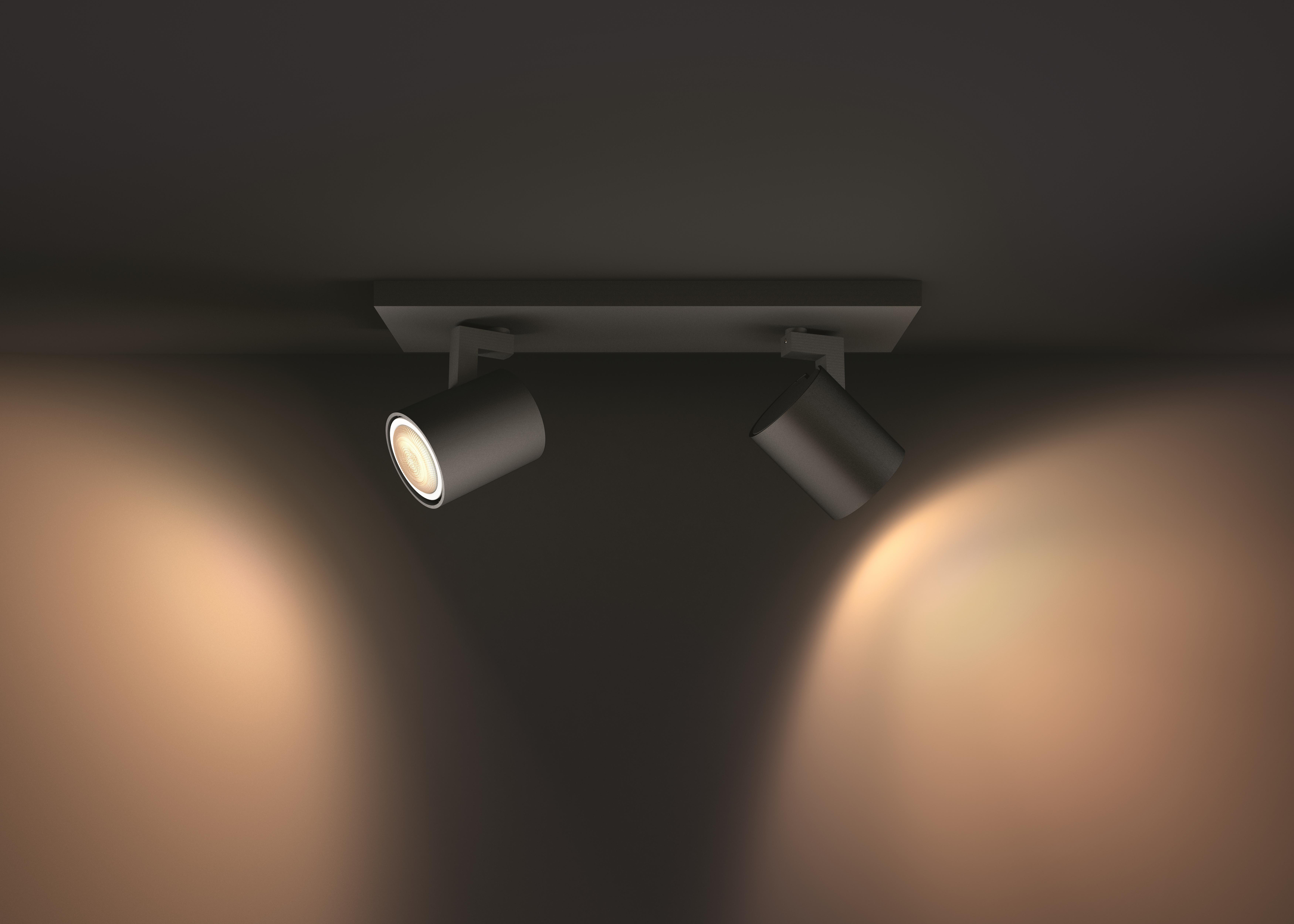 Zwei verstellbare Strahler an einer dunklen Decke montiert, die Licht nach unten werfen.