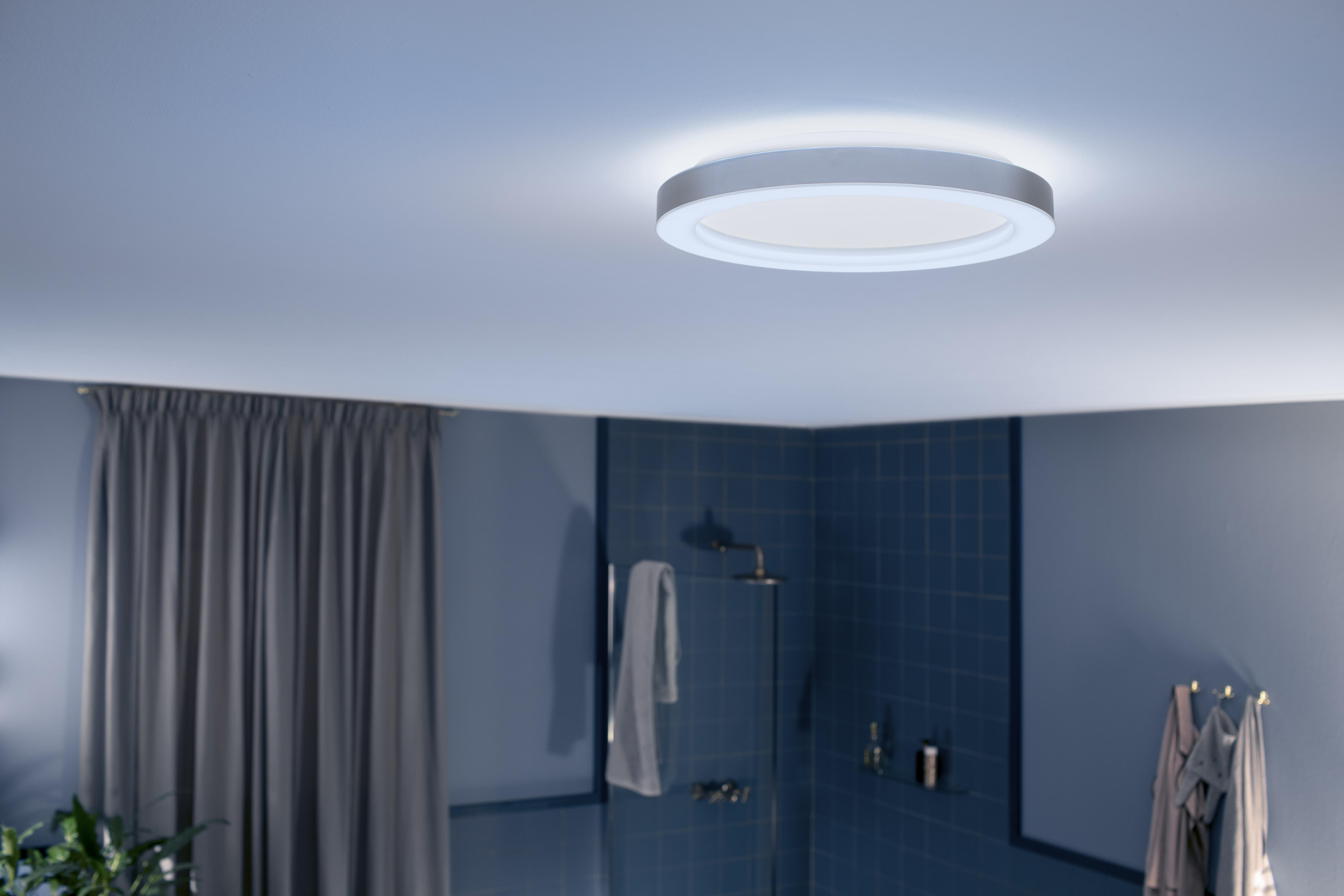 Moderne Deckenleuchte mit kreisförmigem Design, die eine Badezimmerszene mit blauen Wänden und Armaturen beleuchtet.