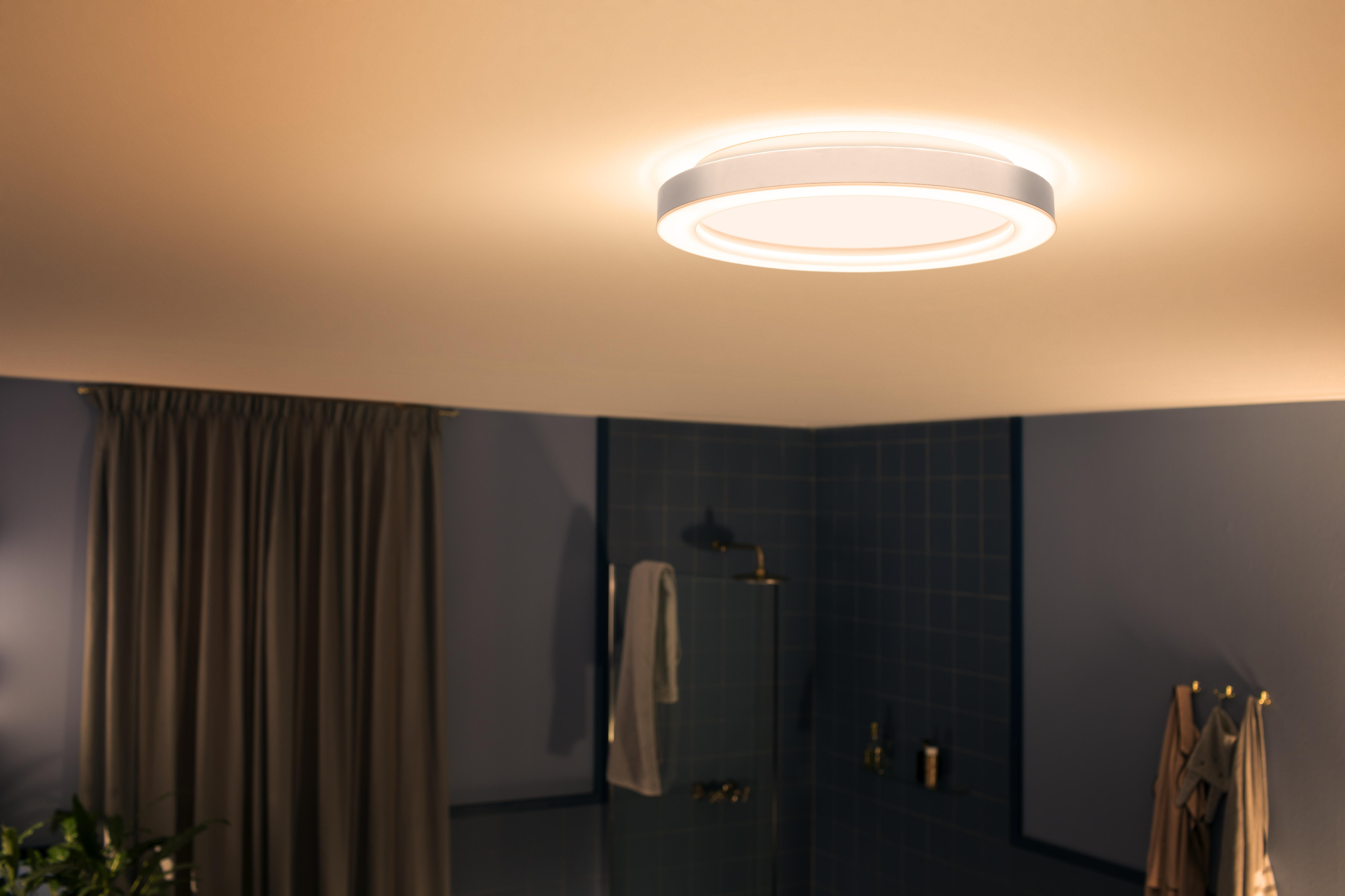 Runde Deckenleuchte. Das Licht ist an. Der Hintergrund beinhaltet ein Badezimmer.