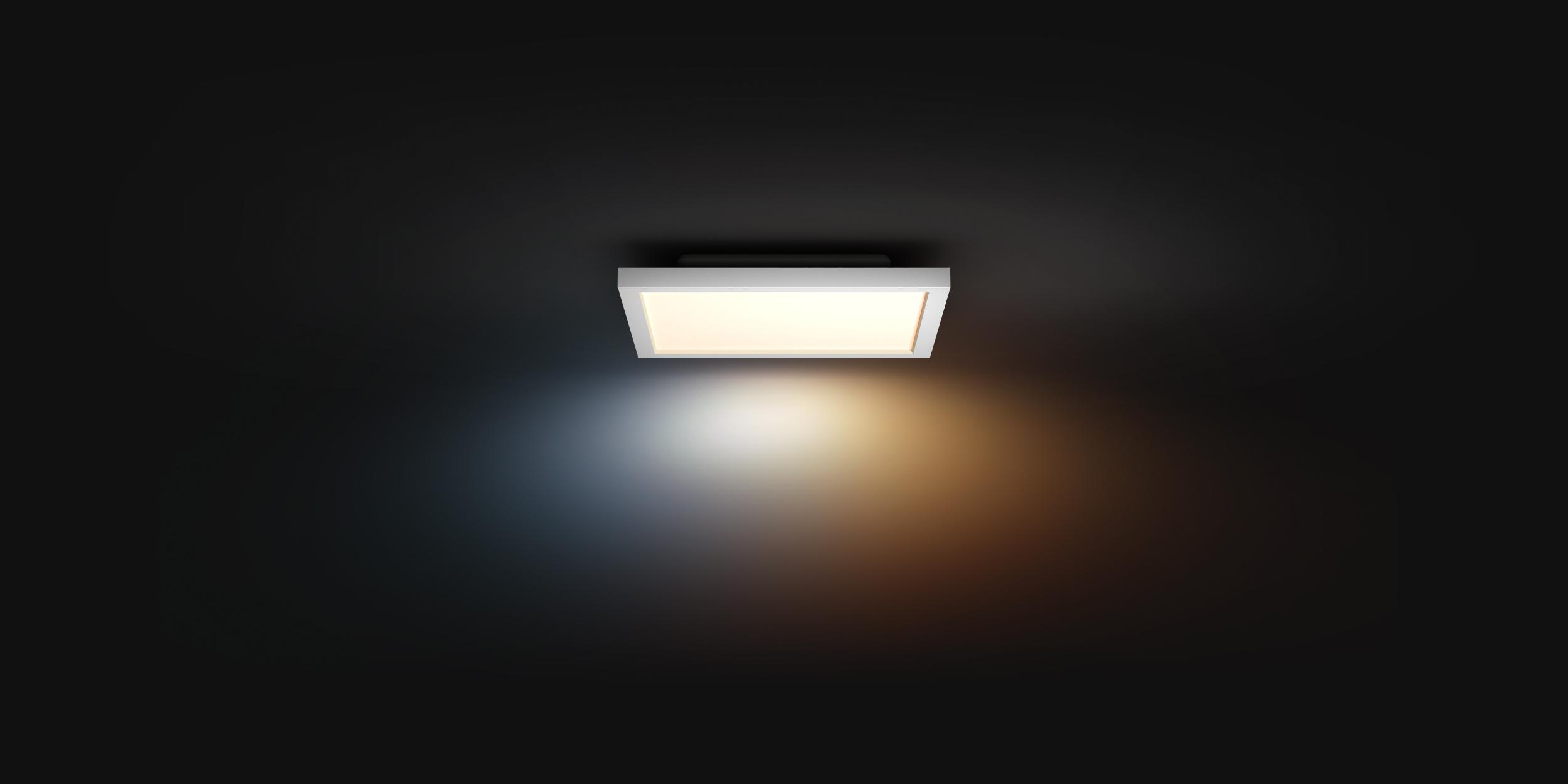 Eine weiße quadratische Deckenleuchte, die Licht auf einem dunklen Hintergrund ausstrahlt.