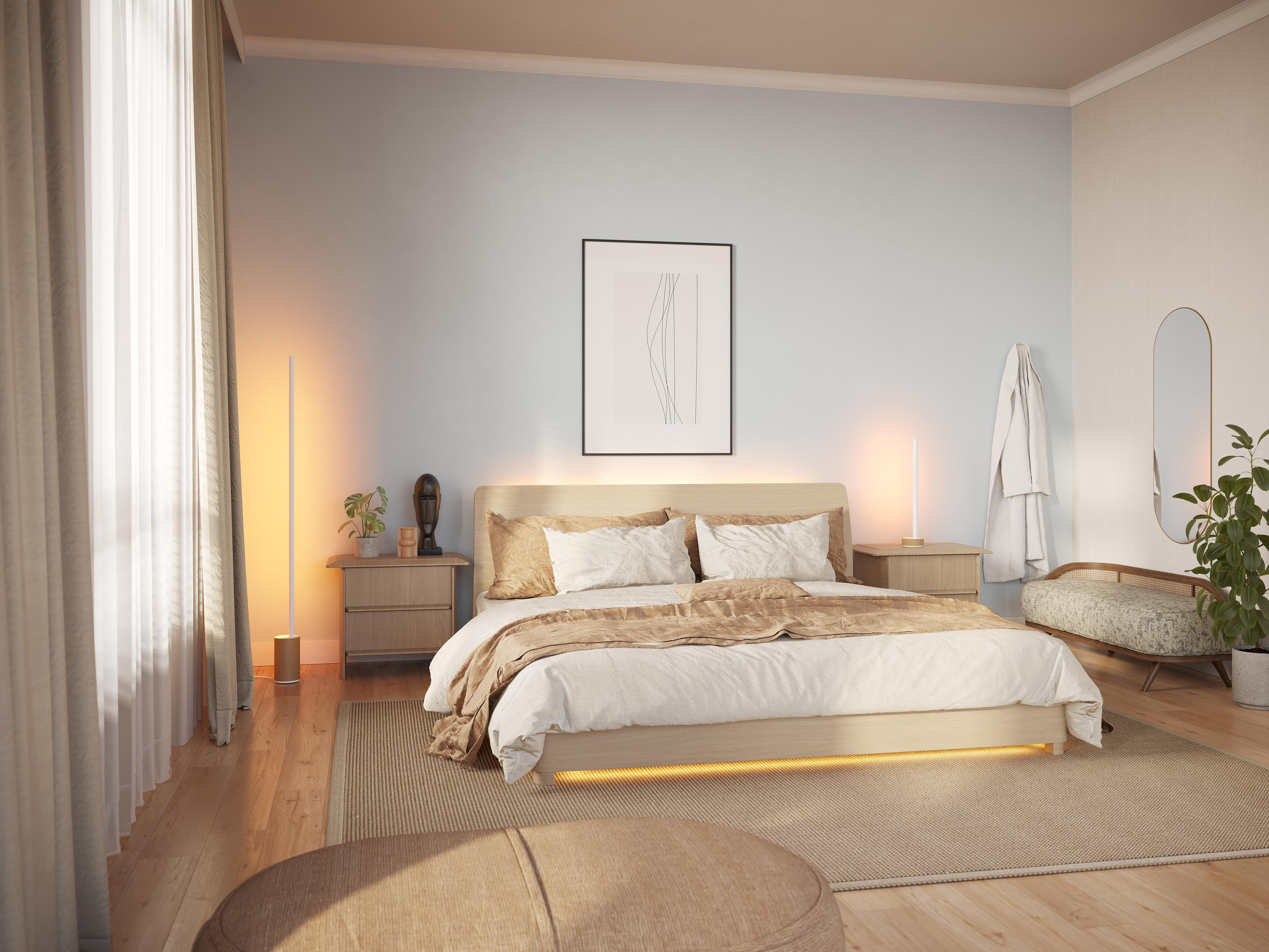 Schlafzimmer mit Bett, Nachttischen, Kunst und Stehlampe. Beige- und helle Holztöne schaffen eine weiche, einladende Atmosphäre.