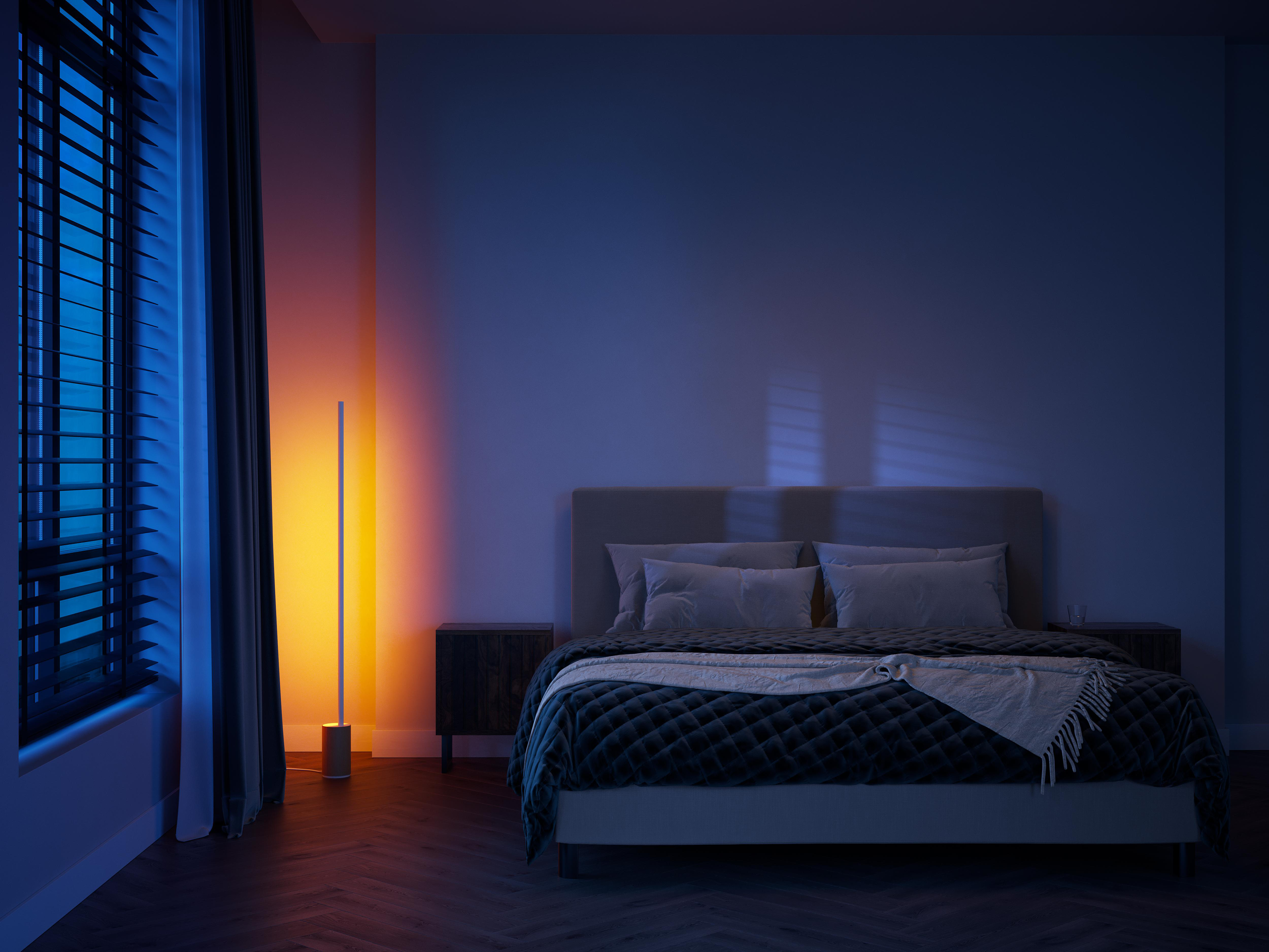 Schlafzimmer mit Stehlampe. Blaues Licht kommt vom Fenster.