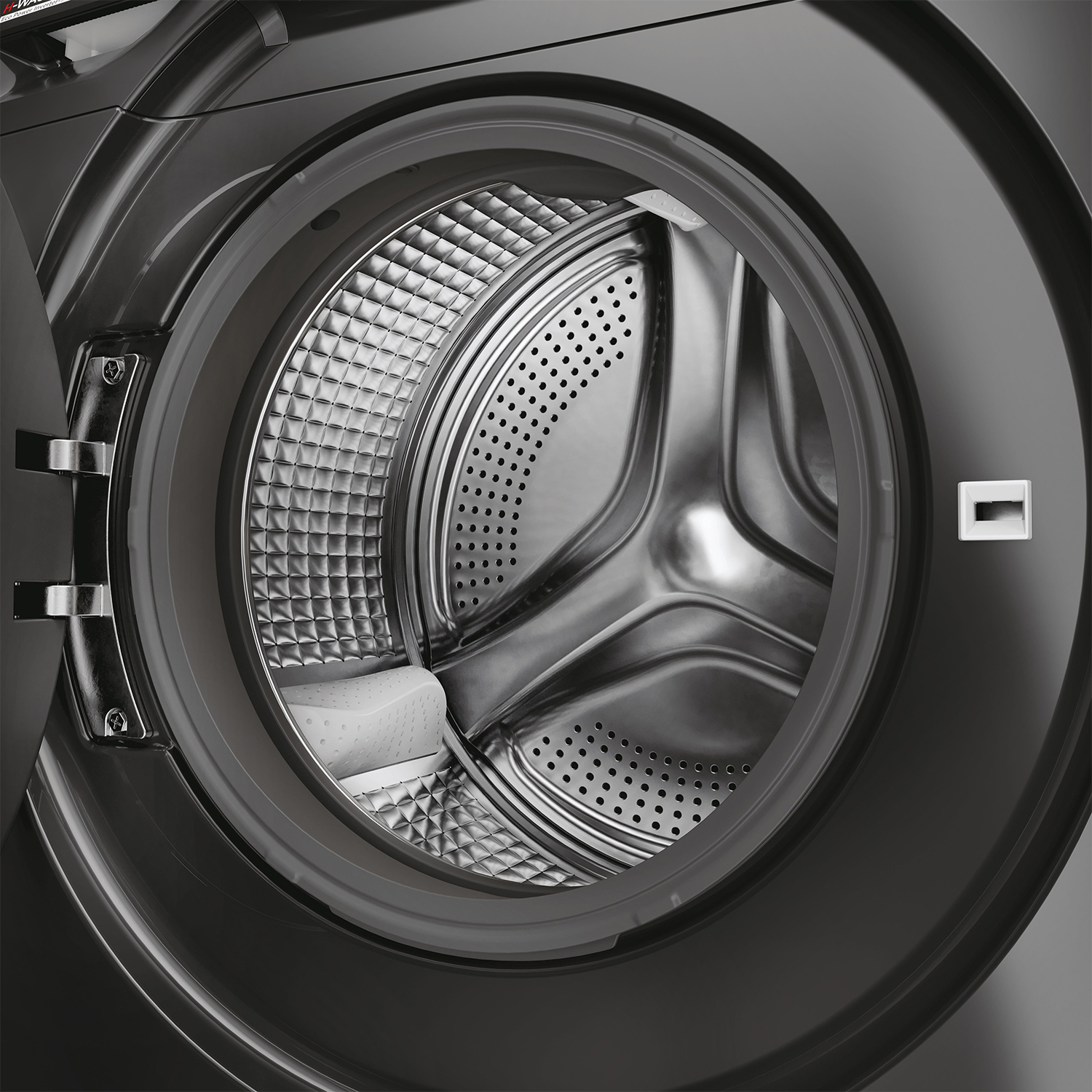 Tamburo aperto di lavatrice nera. Interno in acciaio inox e dispenser detersivo.