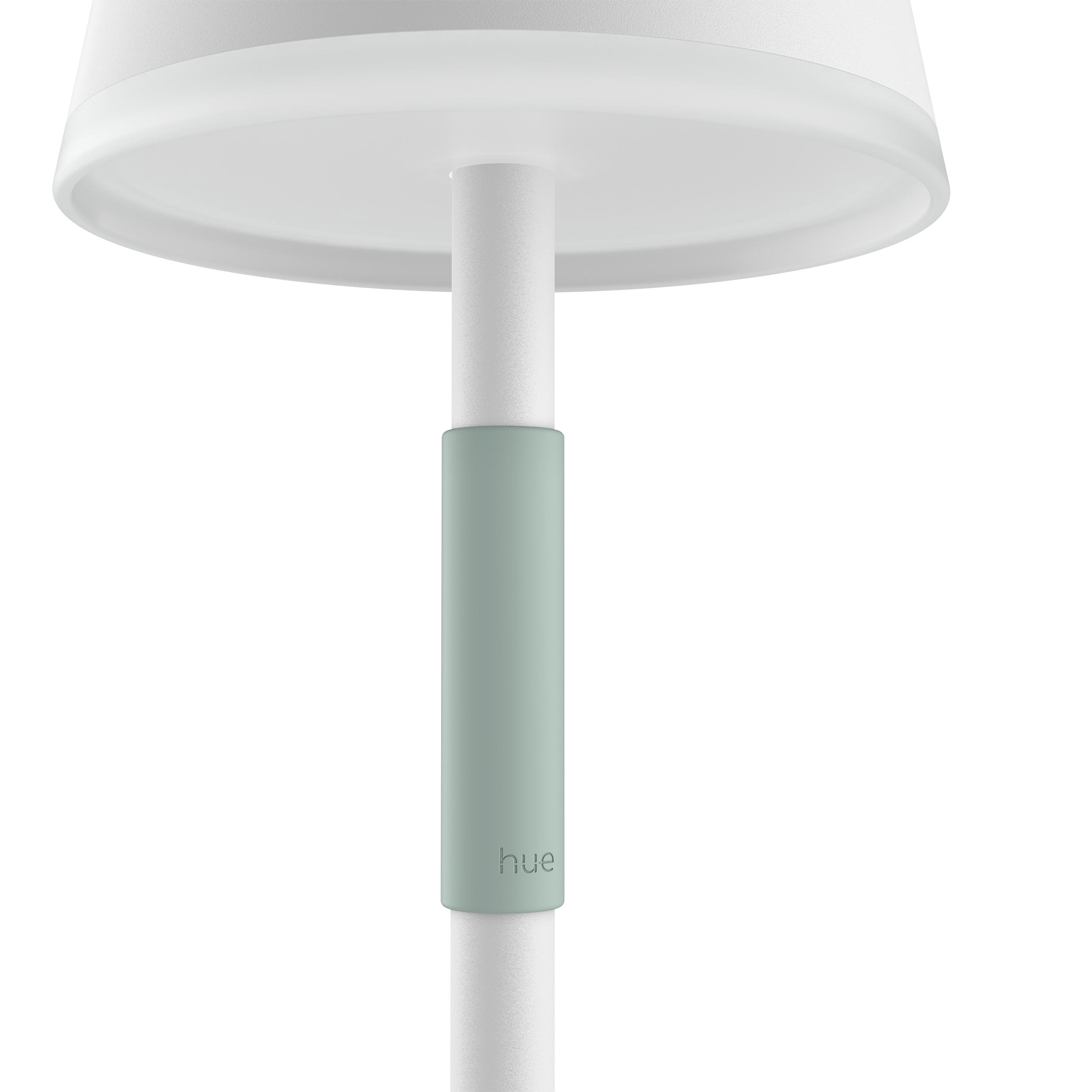 Eine weiße Lampe mit einem grünen Band. Der Stiel ist vertikal. Weißer Hintergrund.