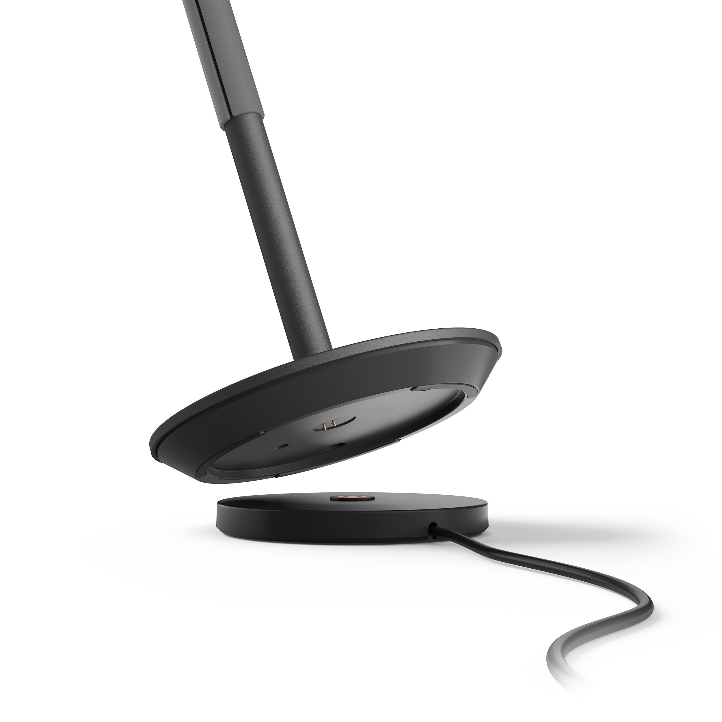 Ein schwarzer Lampensockel mit Kabel und ein schwarzer Lampenstiel, nach oben geneigt.