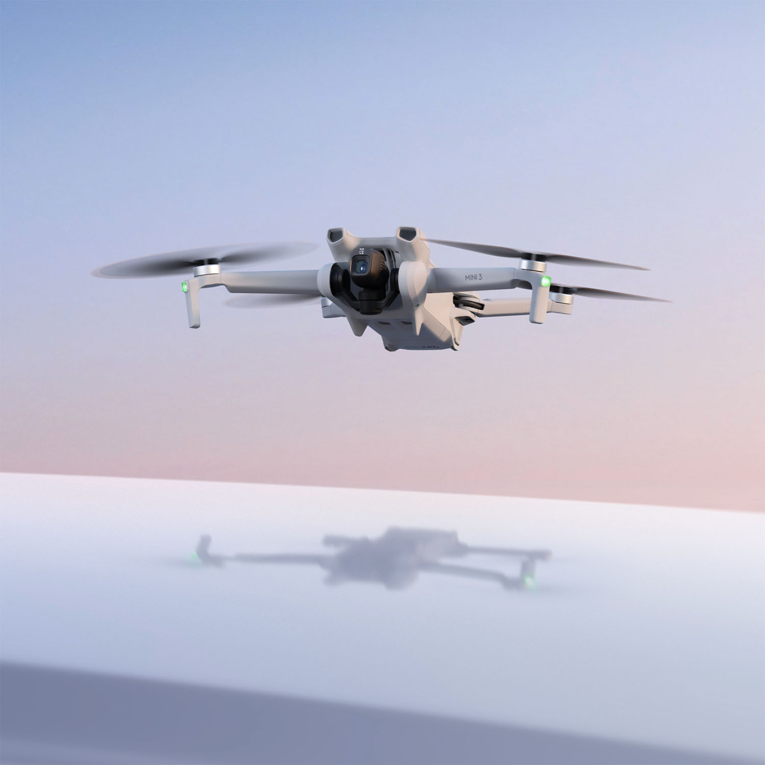 Un drone bianco che vola nel cielo. L'ombra del drone è visibile a terra.