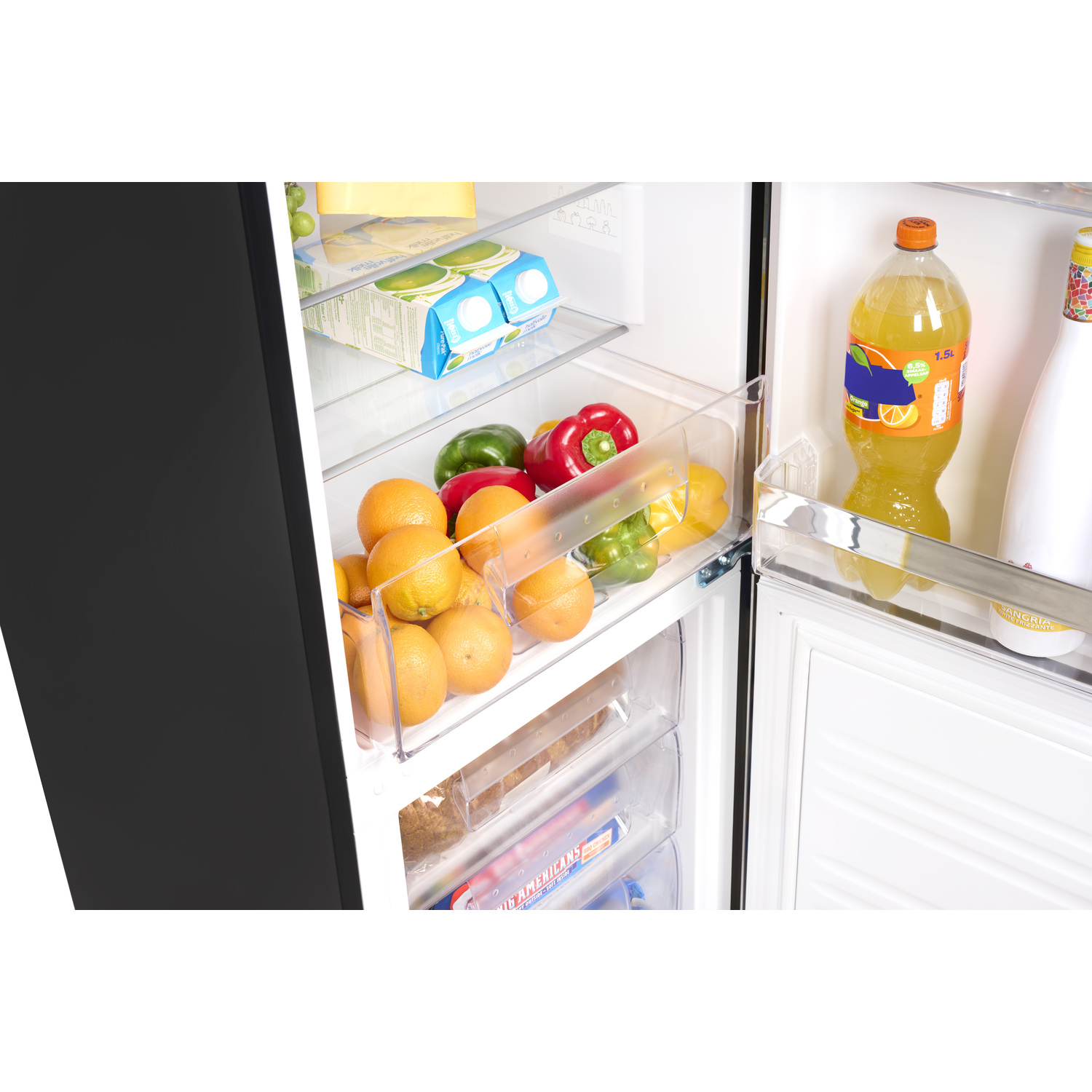 Inside of a refrigerator, showing fruits and vegetables in clear drawers, orange juice, and other items.