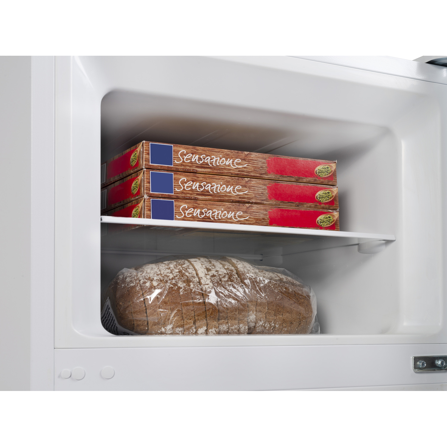 Interior of a freezer with food, including frozen pizzas and a loaf of bread.