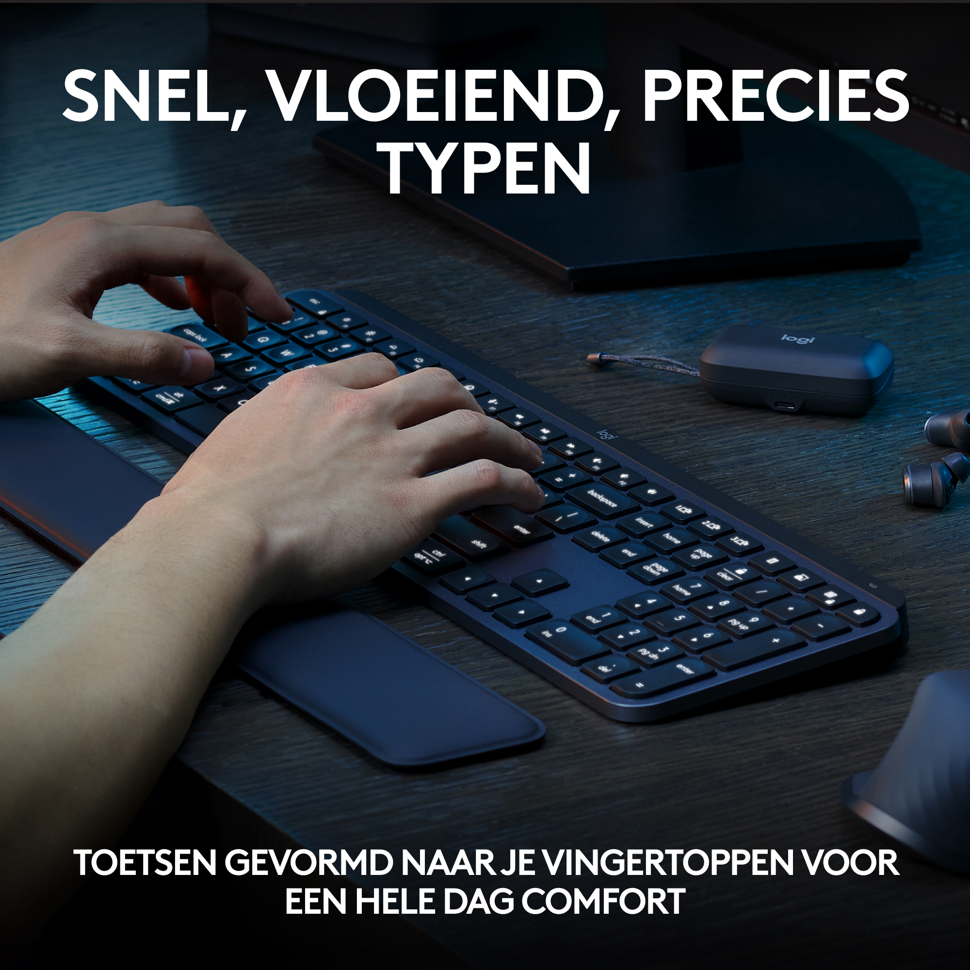 Handen die typen op een donker toetsenbord met polssteun, een muis en oordopjes. De achtergrond is donker.