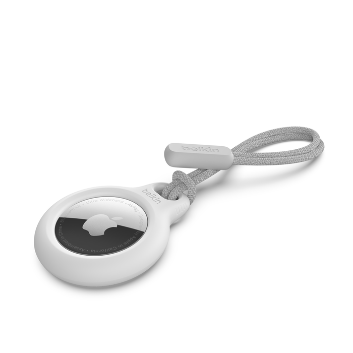 Fehér Apple AirTag szürke szíjjal és Belkin márkajelzéssel.