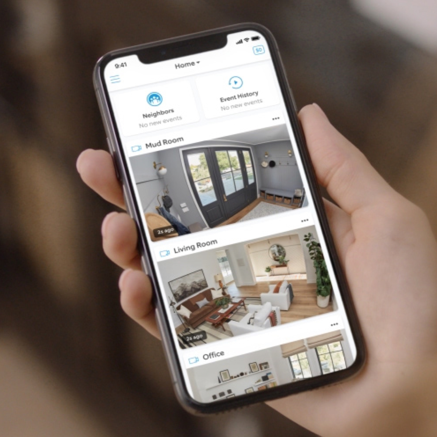 Hand holding a phone, showing multiple home camera views.