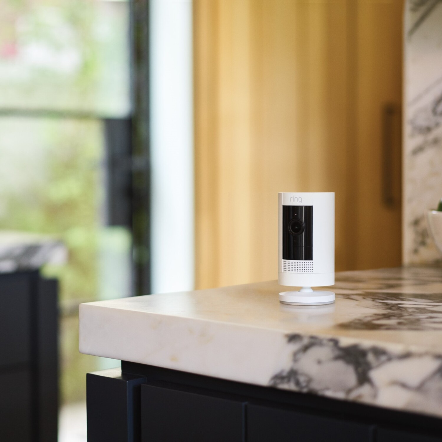A white and black Ring security camera on a countertop.