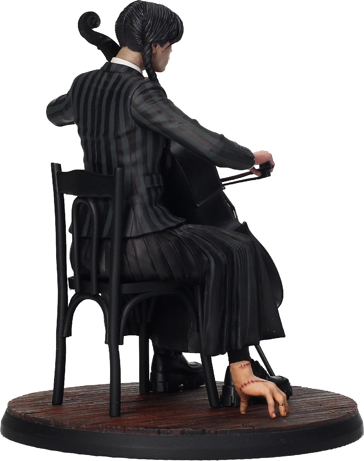 Eine Statue von Wednesday, die Cello spielt, mit einer Hand auf dem Boden.