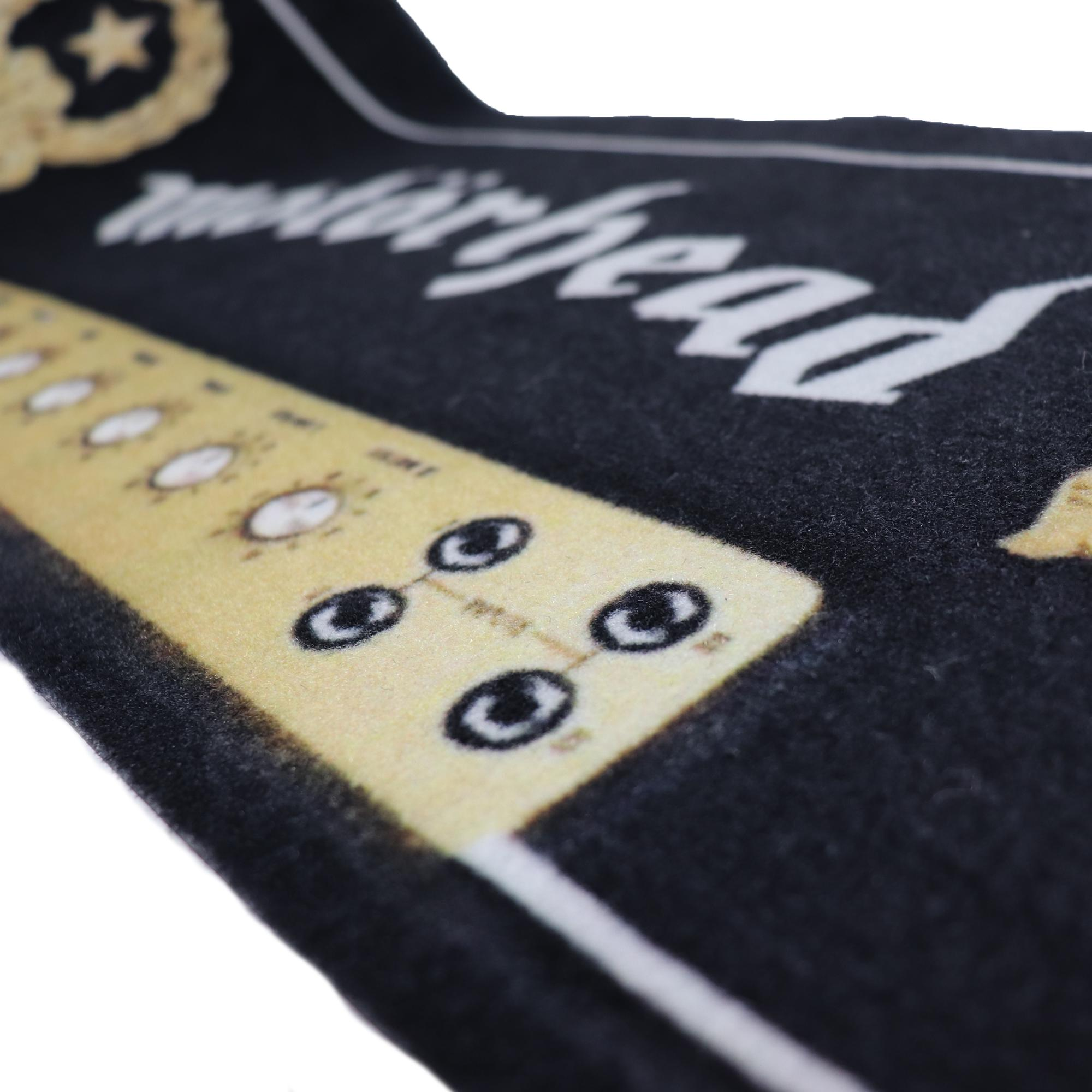 Nahaufnahme einer schwarzen Fußmatte mit Bandlogo und Lautsprecherdesign. Das Wort 'Motörhead' ist sichtbar.