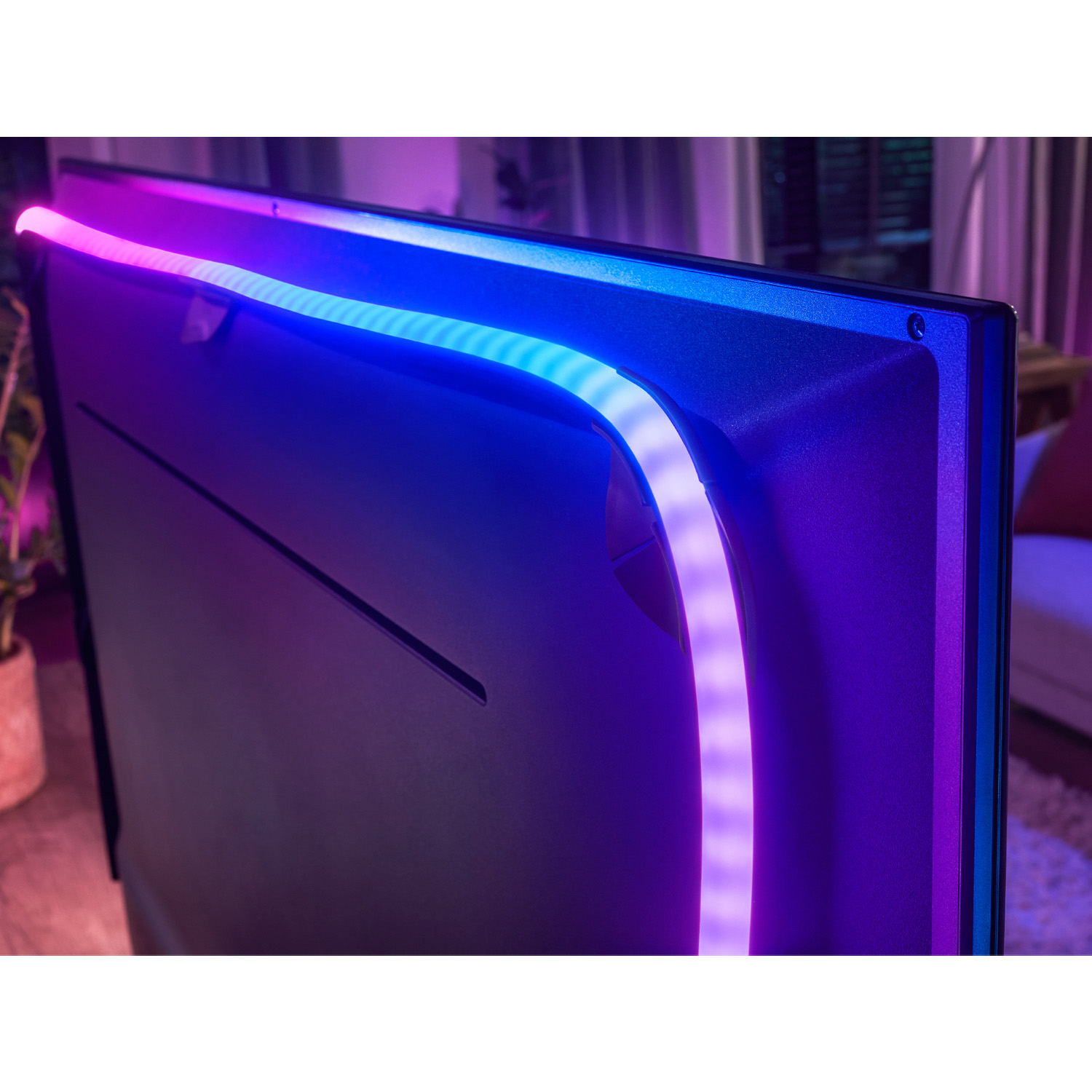 TV con striscia LED sul bordo superiore, che emette luce blu e viola.
