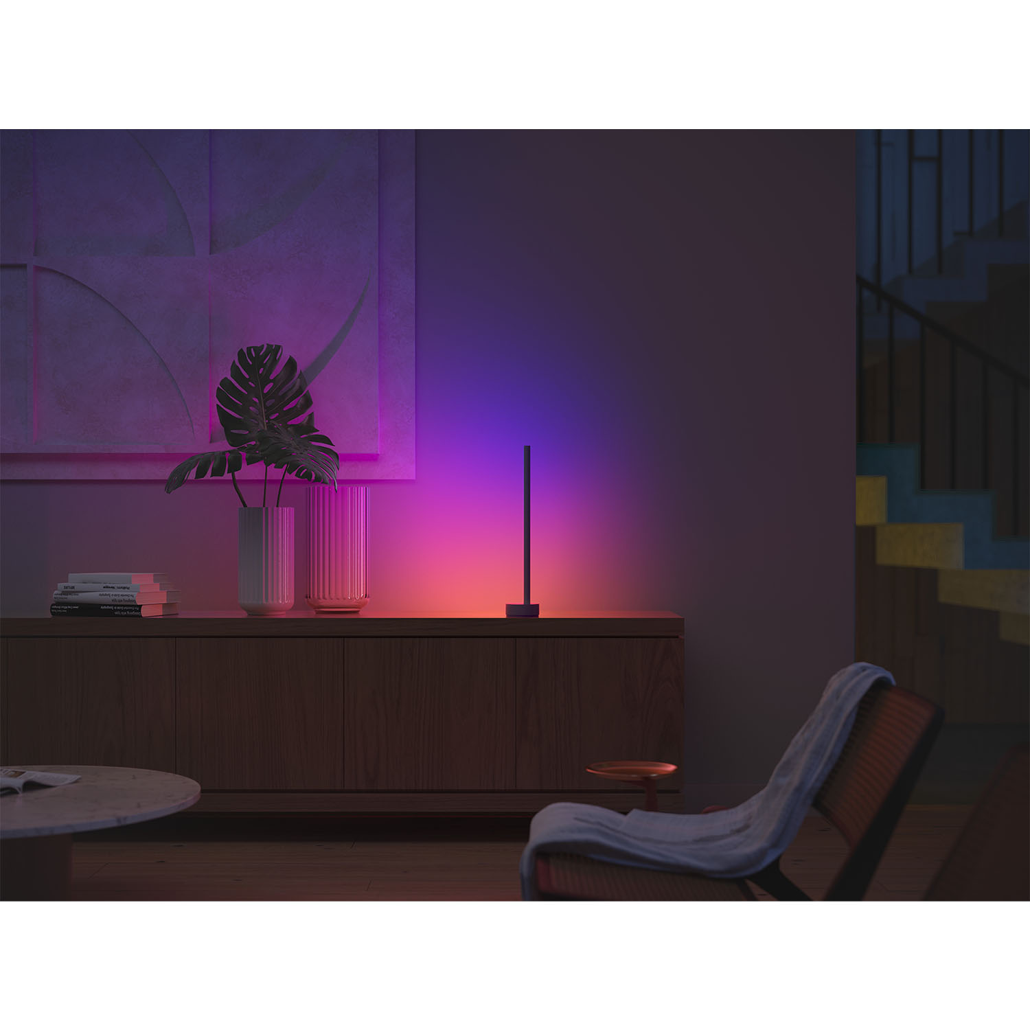 Una lampada nera su un mobile in legno, con luce colorata sullo sfondo.