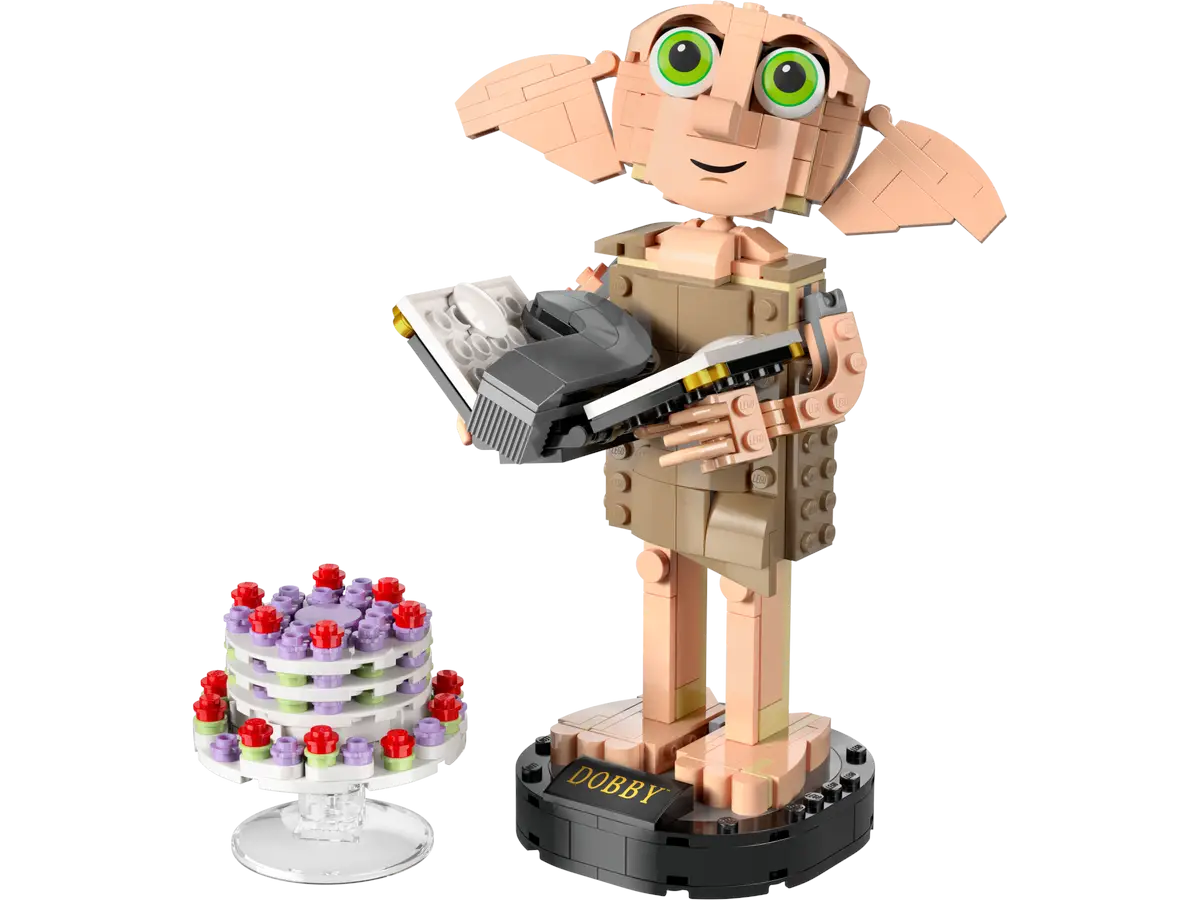 Figurka Lego Dobby trzymająca książkę, obok tort na stojaku.