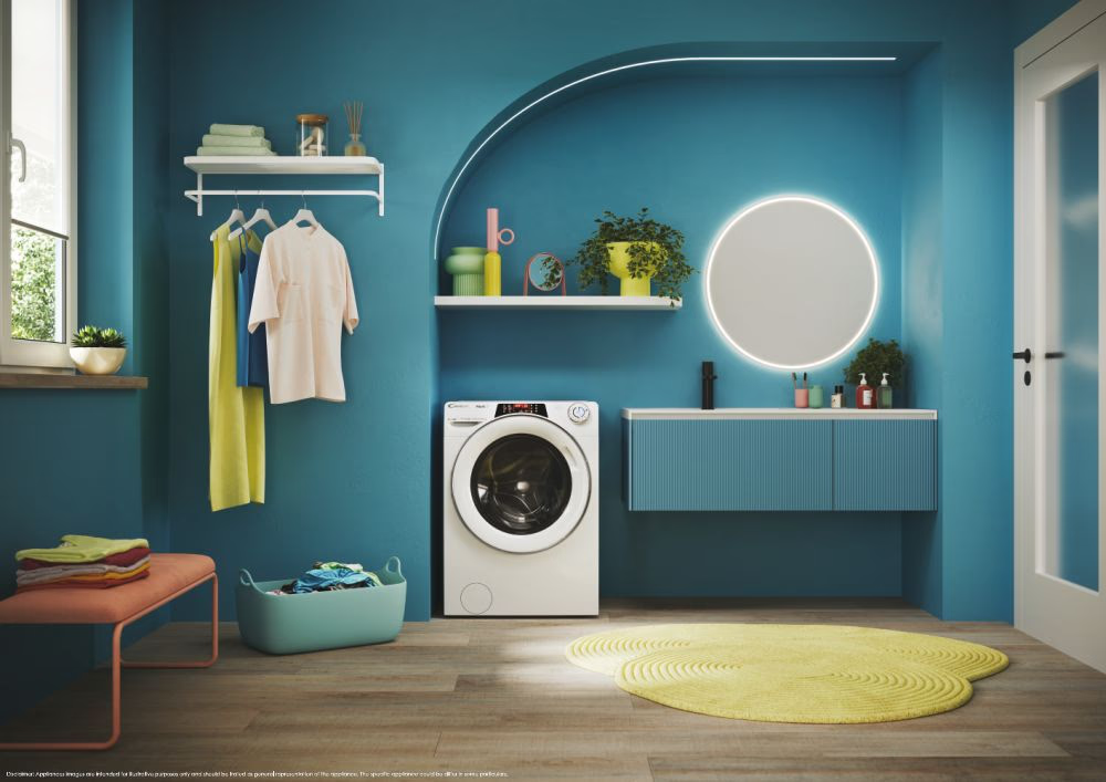 Une salle de bain turquoise avec une machine à laver, des vêtements et de la déco.