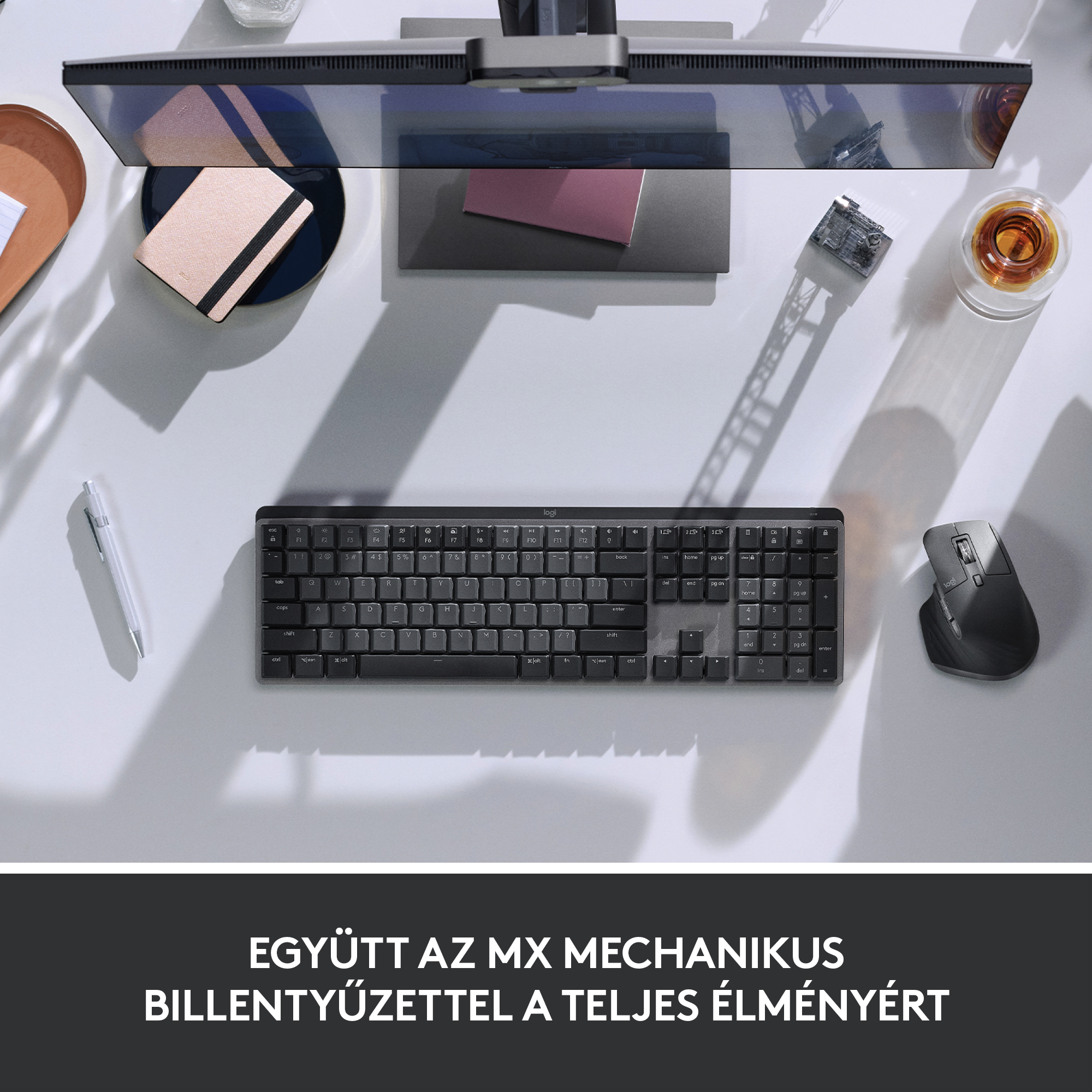 Felülnézet az asztalról billentyűzettel, egérrel, monitorral és jegyzettömbbel. Szöveg alul.