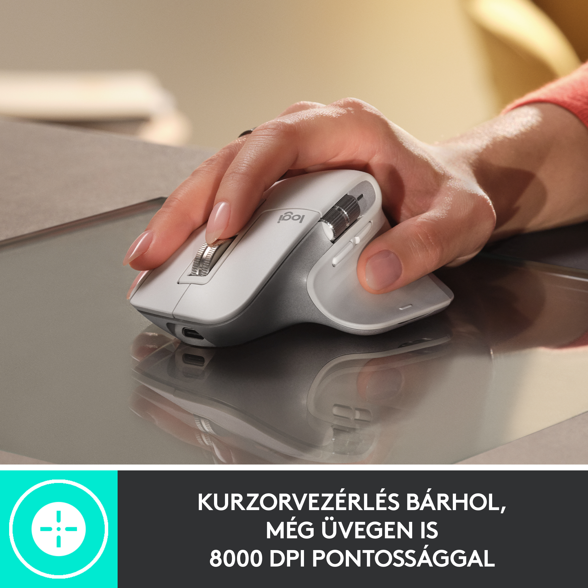 Egy kéz egy fehér és szürke egeret használ az asztalon. Az egér egy ezüst szőnyegen van.