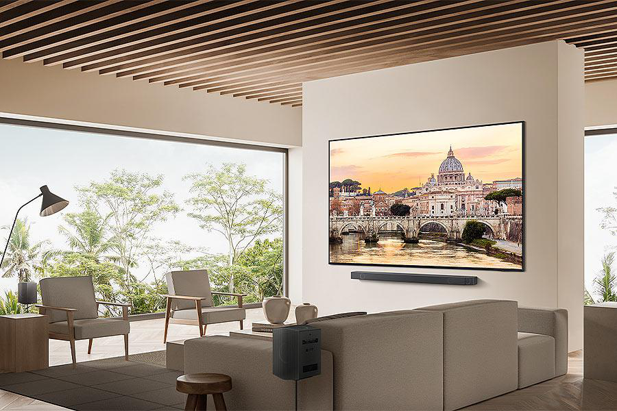 Ein modernes Wohnzimmer mit einem großen TV an der Wand, einem Sofa und einer Stadtansicht durch ein Fenster.