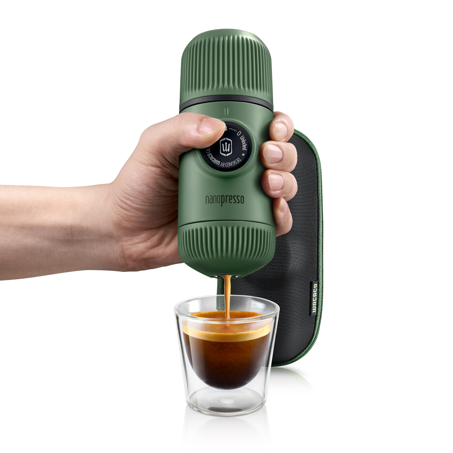 Groene draagbare espressomaker. Hand houdt hem vast, schenkt espresso in een glas. Zwarte draagtas.