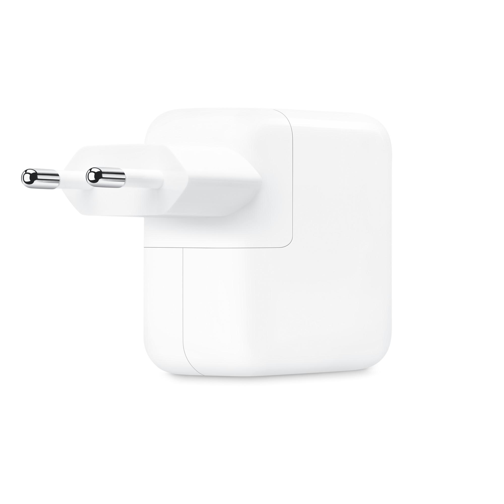 Weißes Apple-Wandladegerät mit zwei metallischen Stiften. Es ist eingesteckt und bereit zum Aufladen.