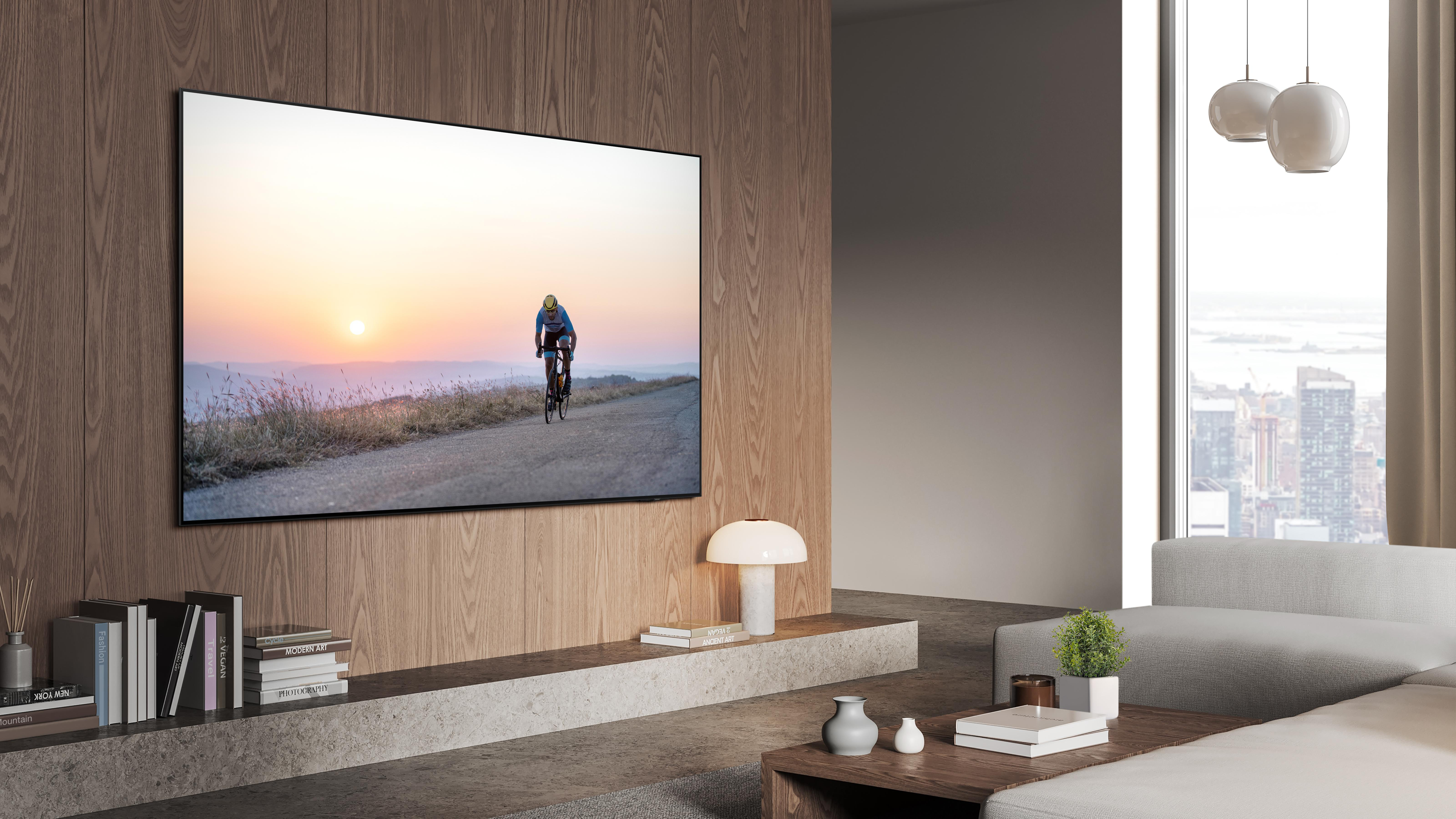 Ein großer Bildschirm-TV mit Radfahrerbild, Holzwand und Innenszene.