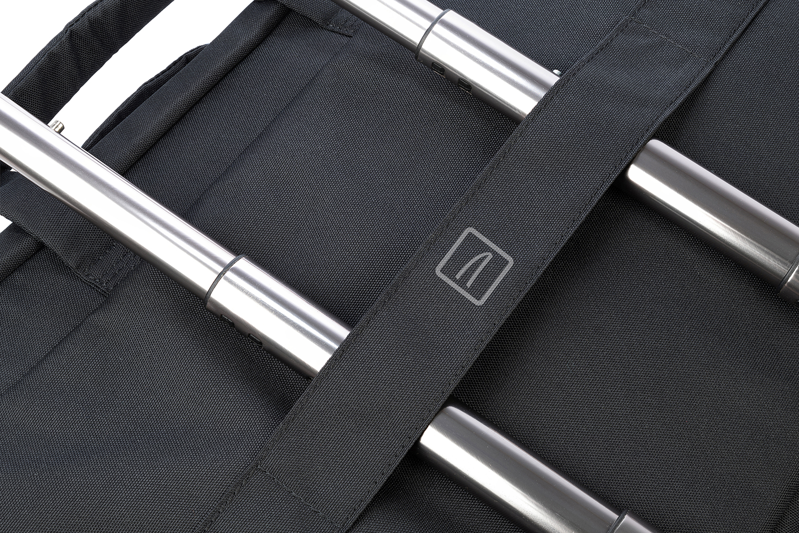 Gros plan d'un sac noir avec des barres métalliques argentées et une sangle avec un logo.