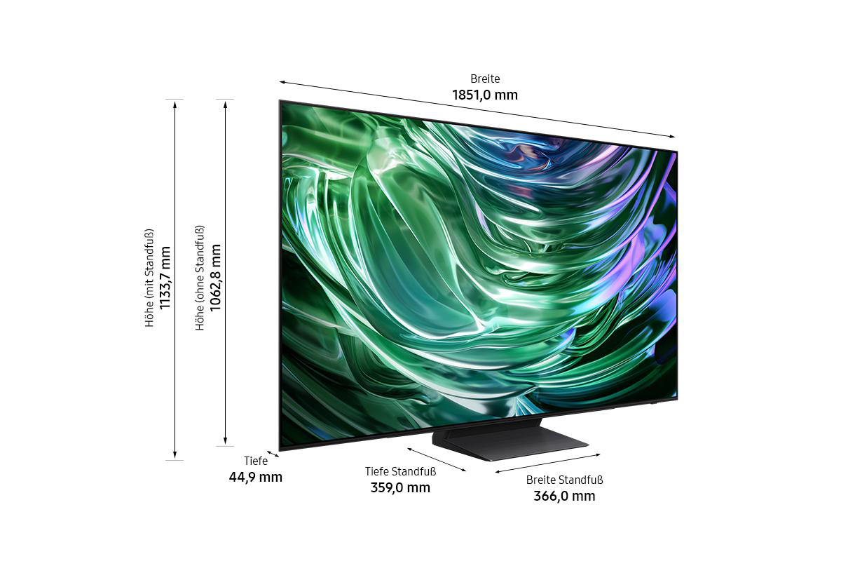 Großer Fernseher mit Maßen. Bildschirm zeigt abstrakte grüne und violette Formen. Schwarzer Ständer unten.