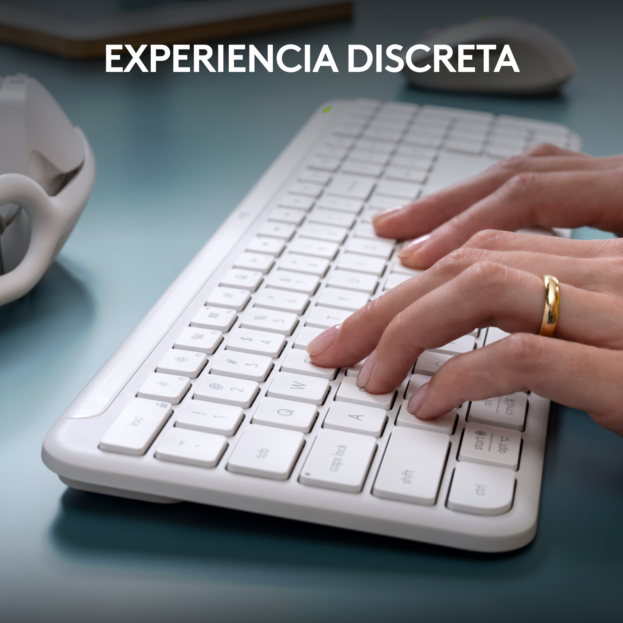 Manos tecleando en un teclado blanco, con el texto "EXPERIENCIA DISCRETA" arriba.