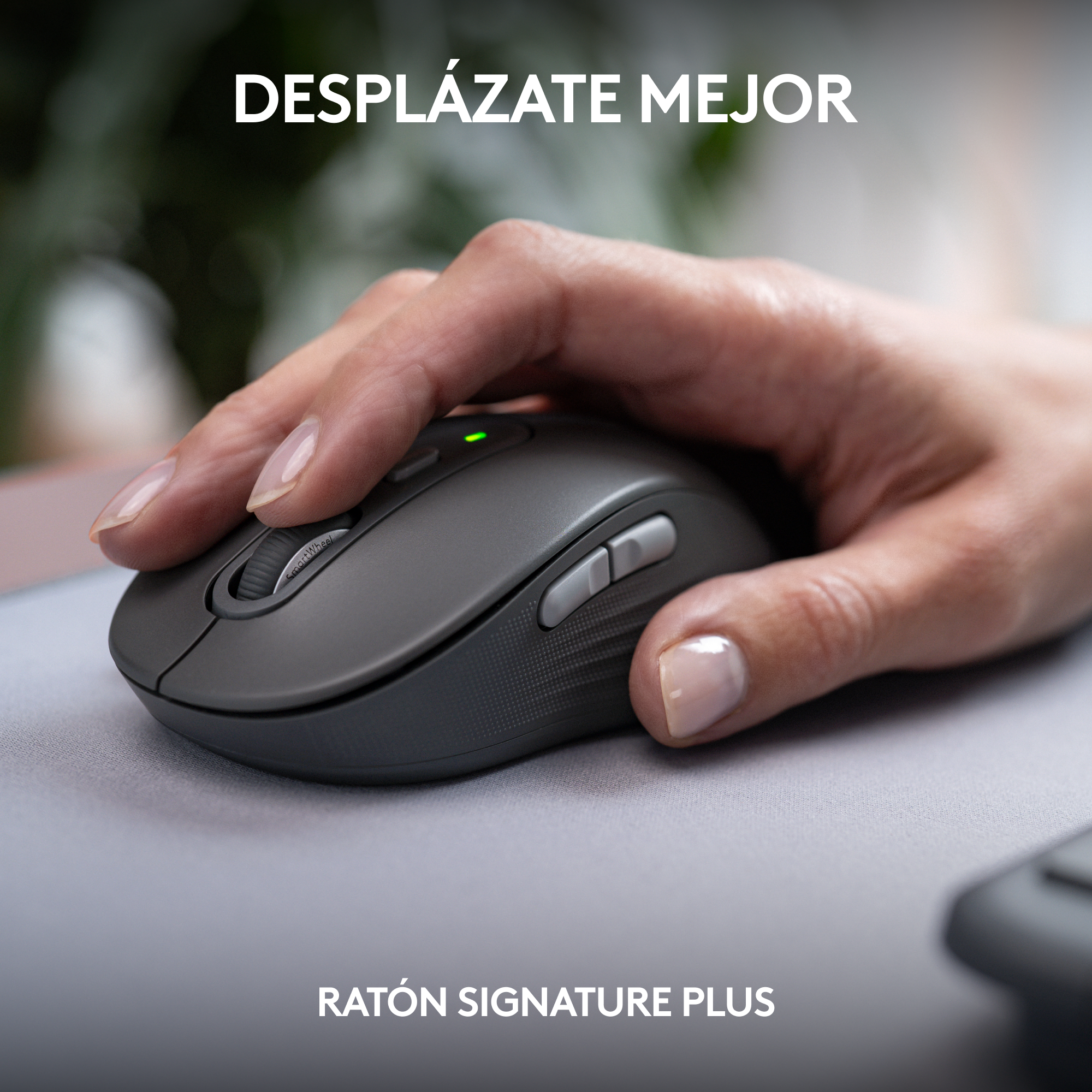 Mano sosteniendo un ratón gris sobre una alfombrilla gris, con el texto 'DESPLÁZATE MEJOR' arriba.