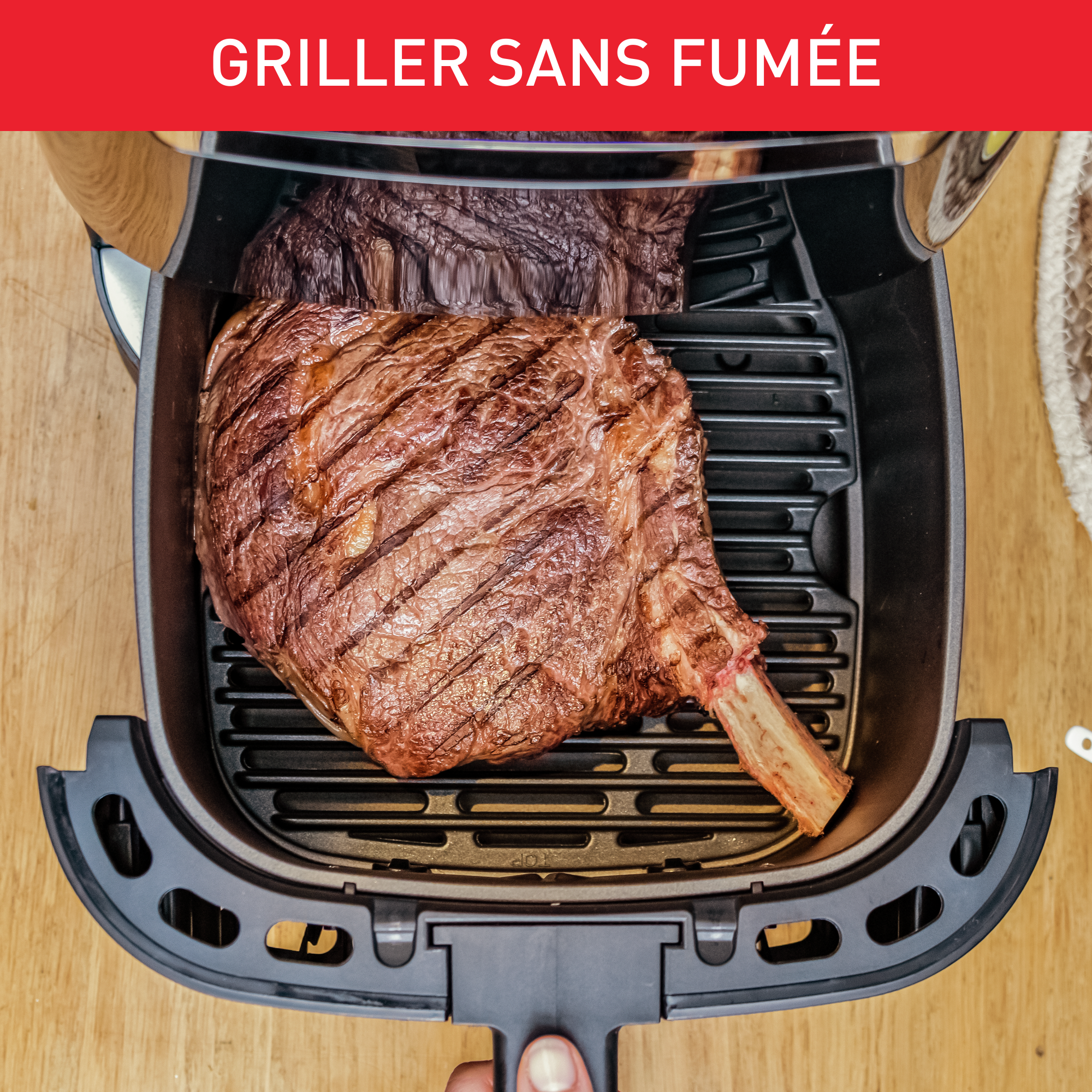 Un steak est grillé dans un appareil. Le texte dit Griller sans fumée. L'appareil est sur une table en bois.