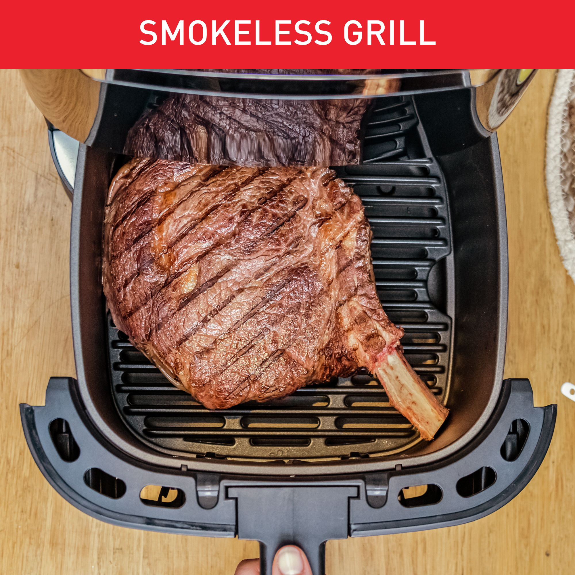 Een grill met twee steaks. Tekst bovenaan: 'SMOKELESS GRILL'.