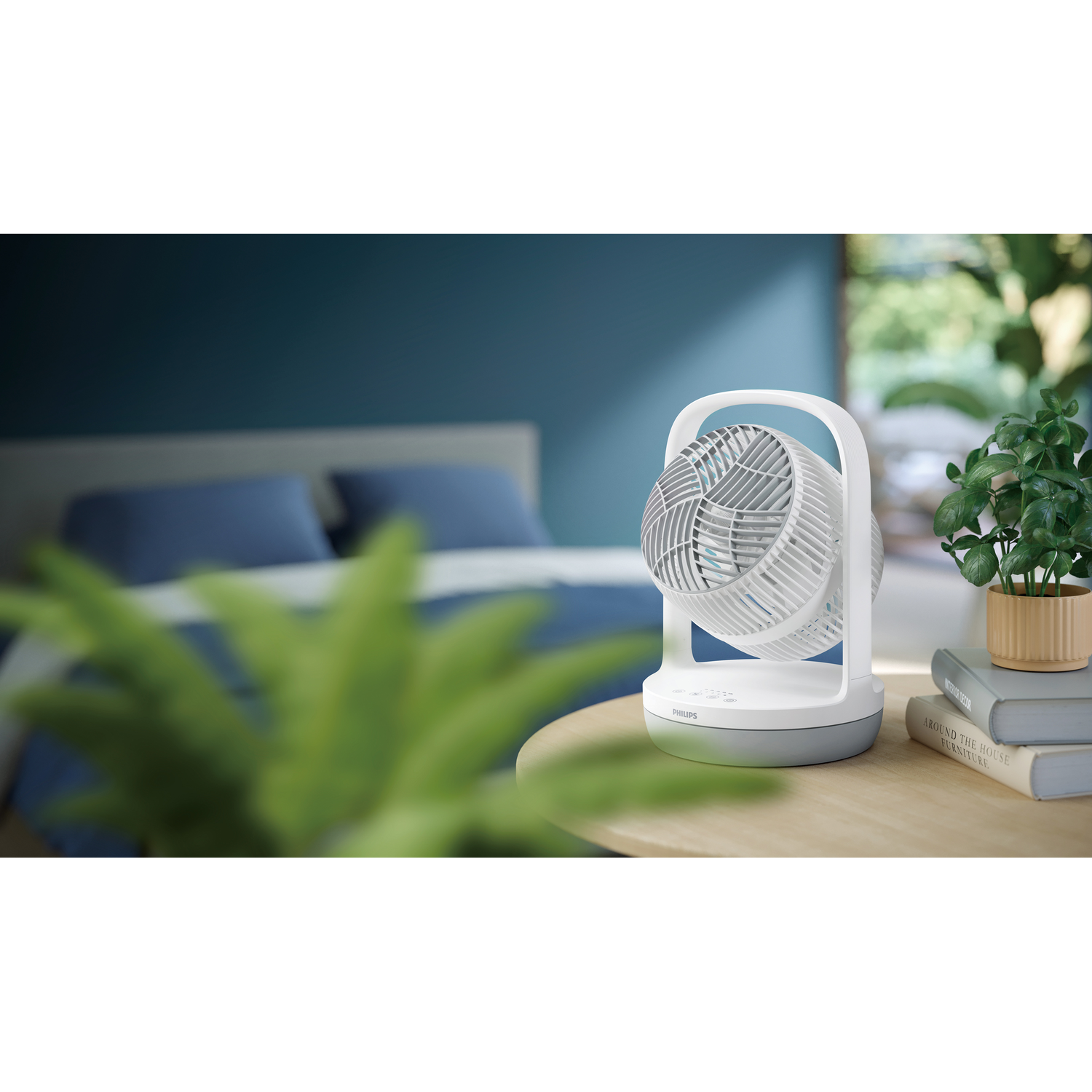 Witte en grijze ventilator op tafel. Slaapkamer op de achtergrond met bed.
